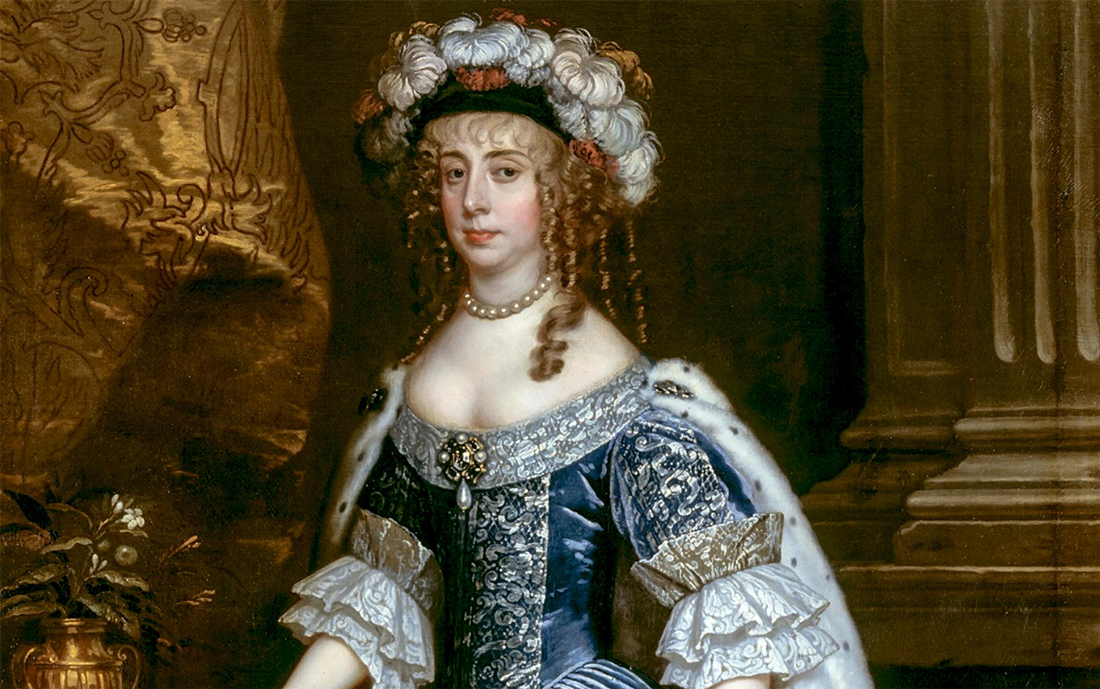 A historical painting of a woman in a detailed blue and silver gown with lace sleeves. She wears a pearl necklace and a hat adorned with white and pink flowers. The background features a golden tapestry and dark pillars.