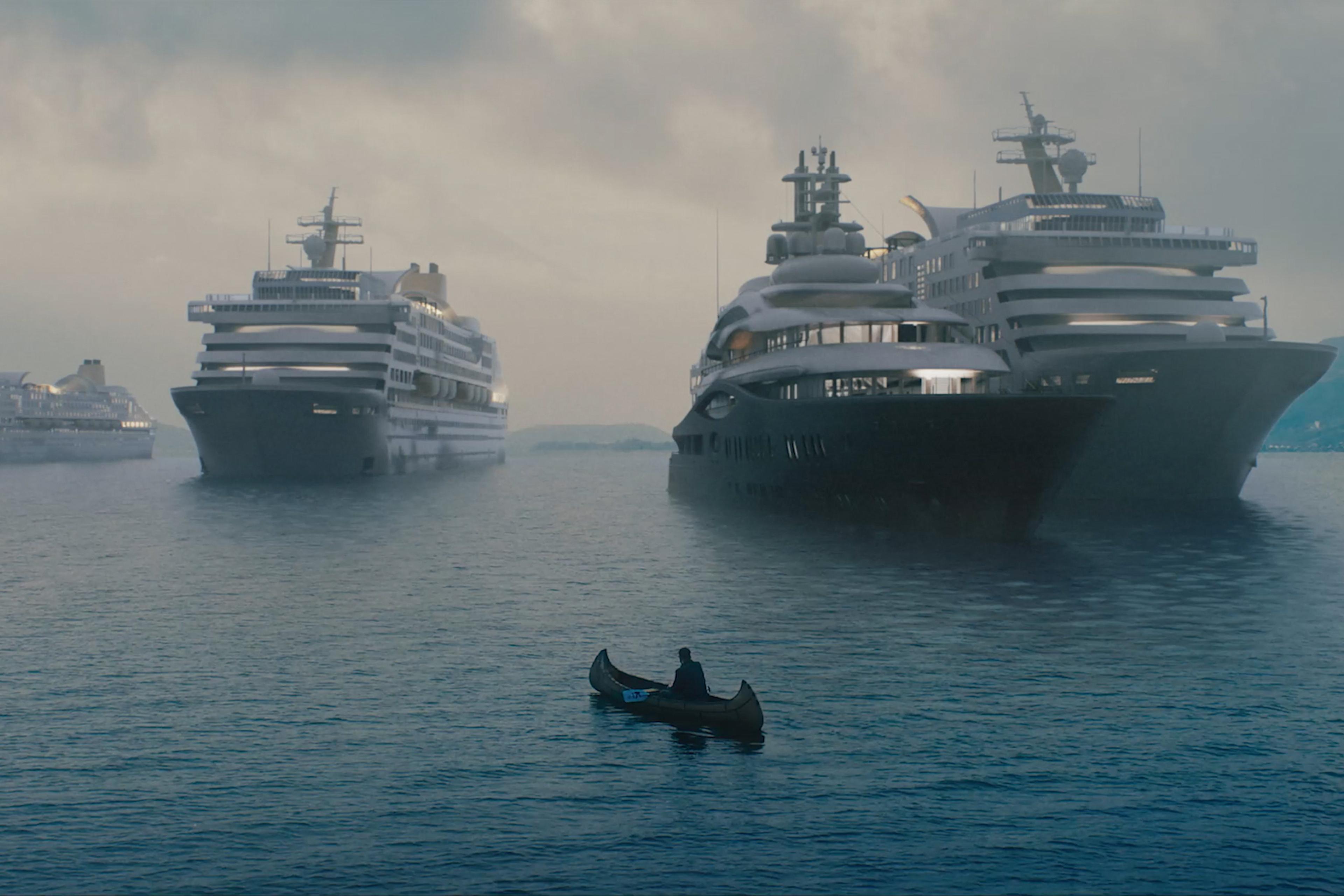Photo of a person in a small canoe surrounded by large cruise ships under a cloudy sky.