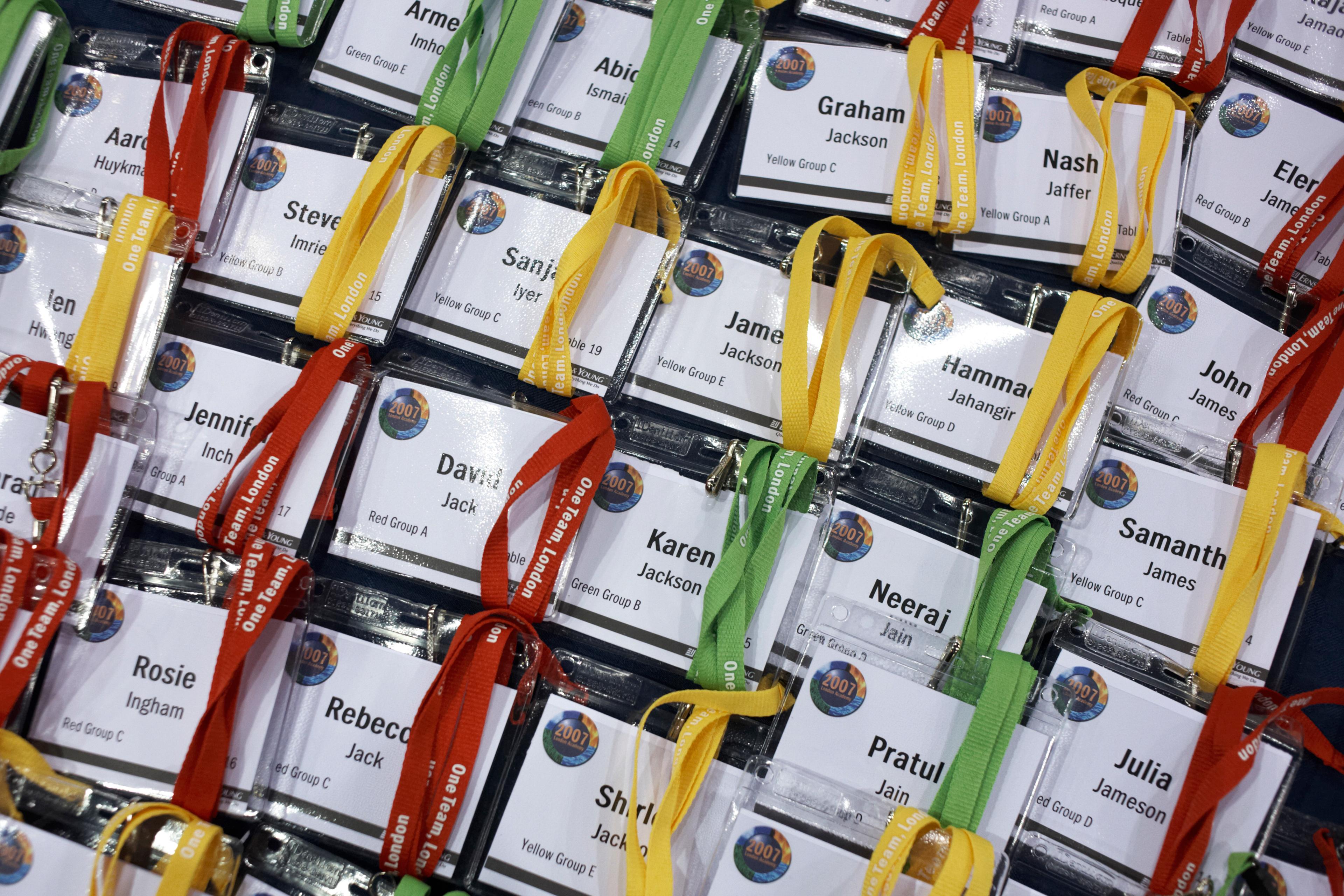Photo of name badges with coloured lanyards for an event laid out in a grid pattern.