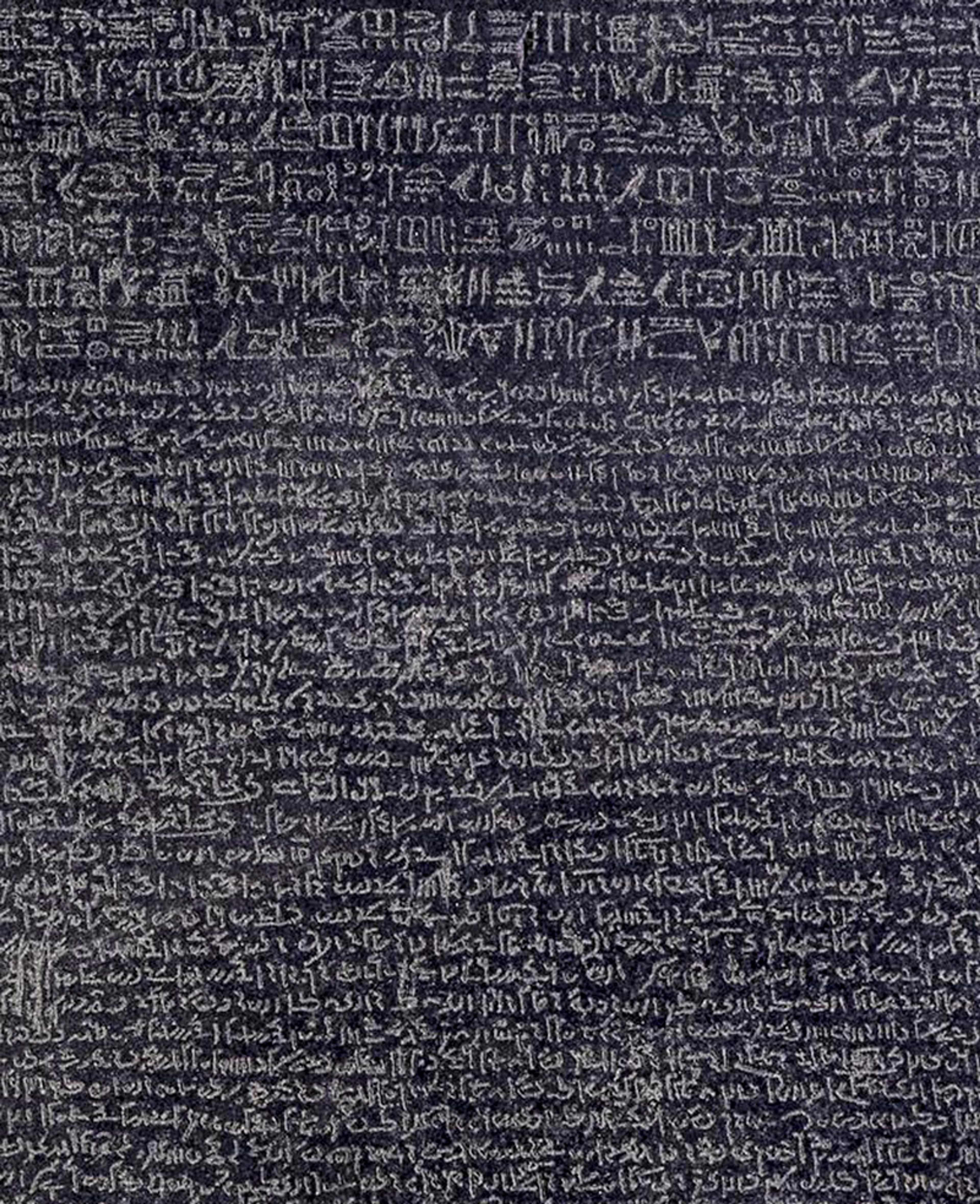 Close-up photo of the Rosetta Stone, showing text in three scripts: hieroglyphic, demotic Egyptian and ancient Greek.