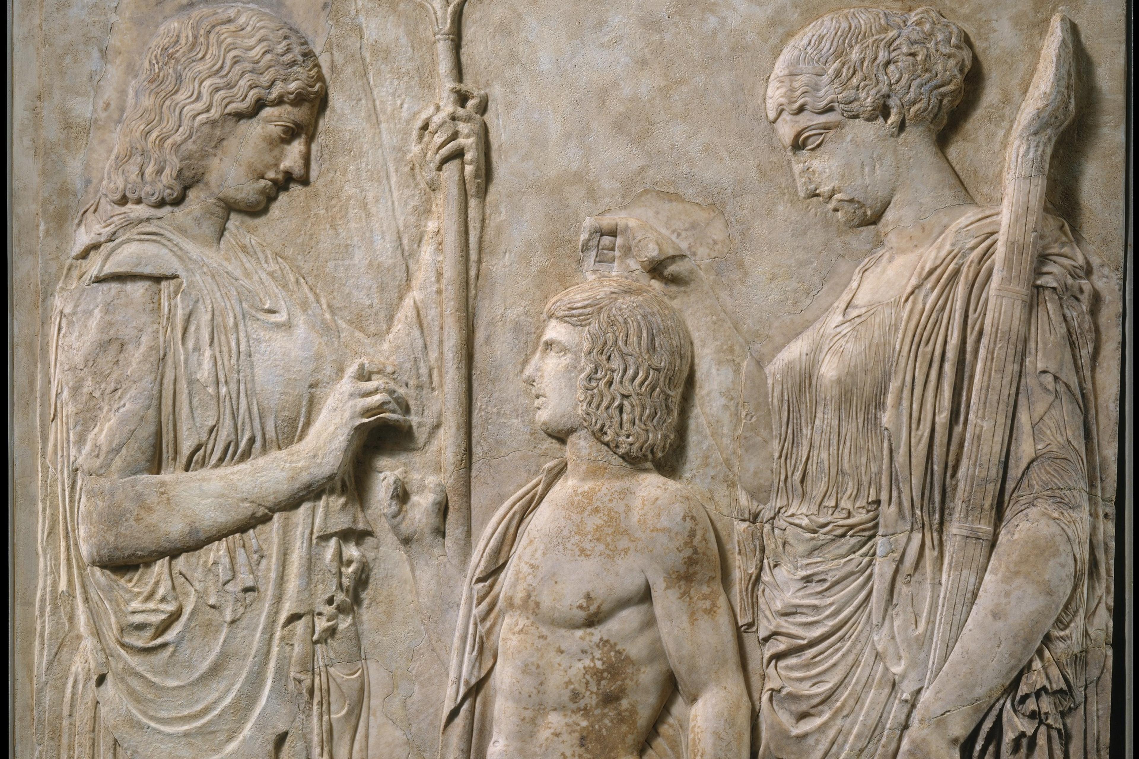 Ancient Greek marble relief showing three figures in a carved scene.