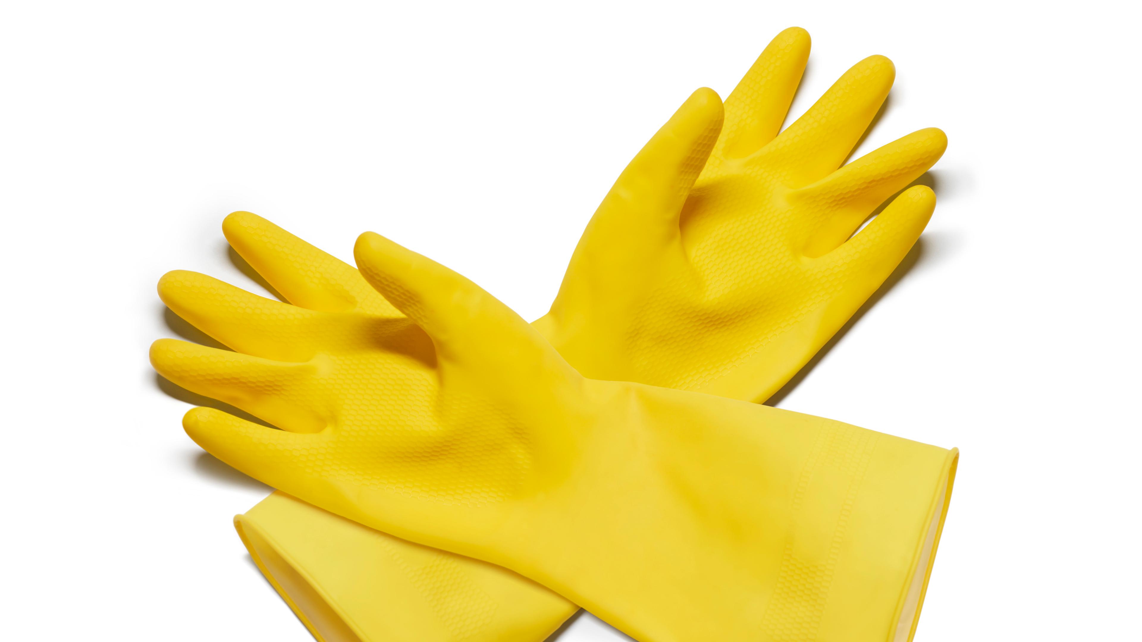 Photo of a pair of yellow rubber gloves on a white background.