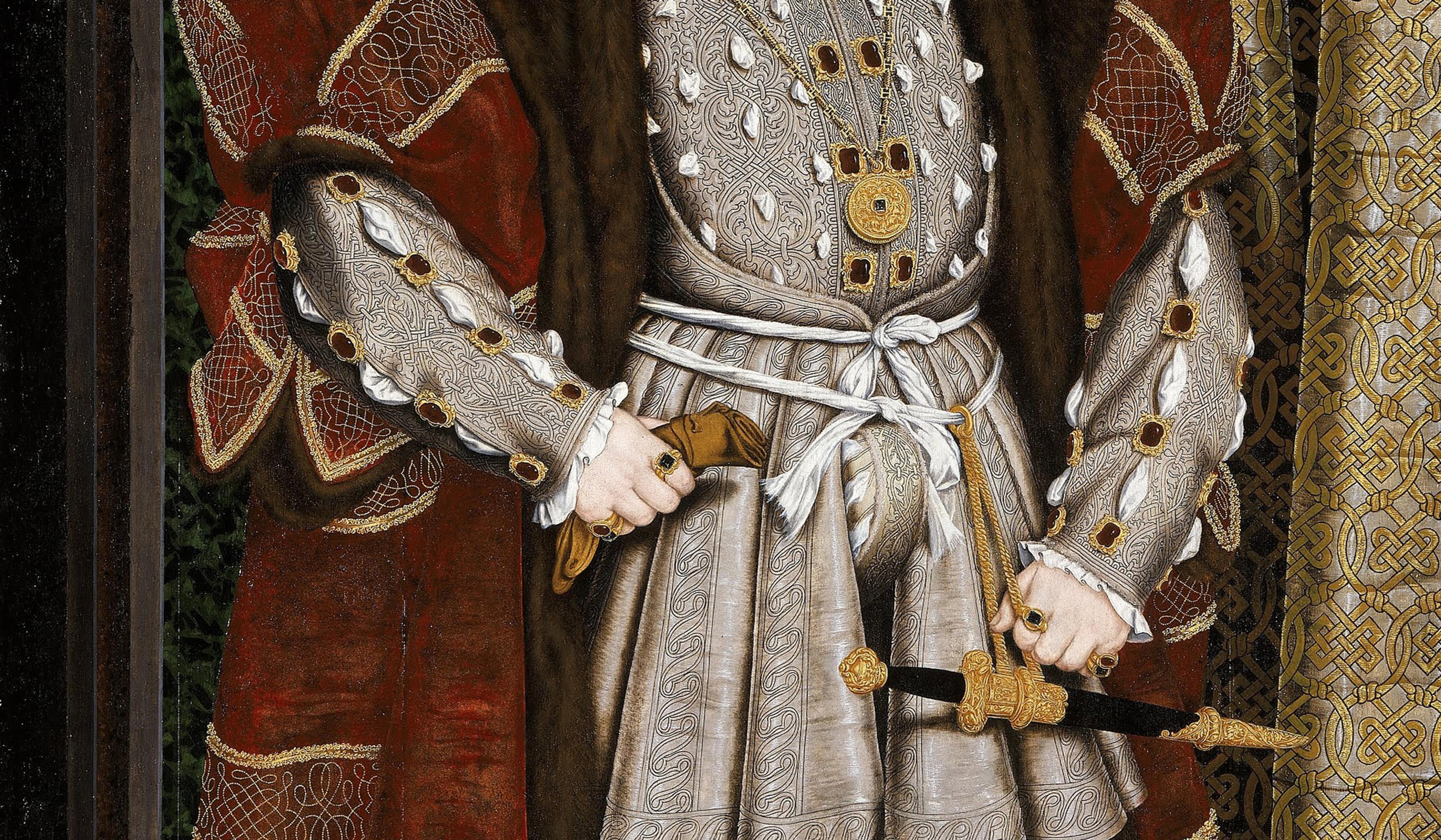 A rich Tudor-era outfit with elaborate brocade, fur trimming and jewellery, featuring ornate sleeves, a belt, and a robe with intricate patterns.