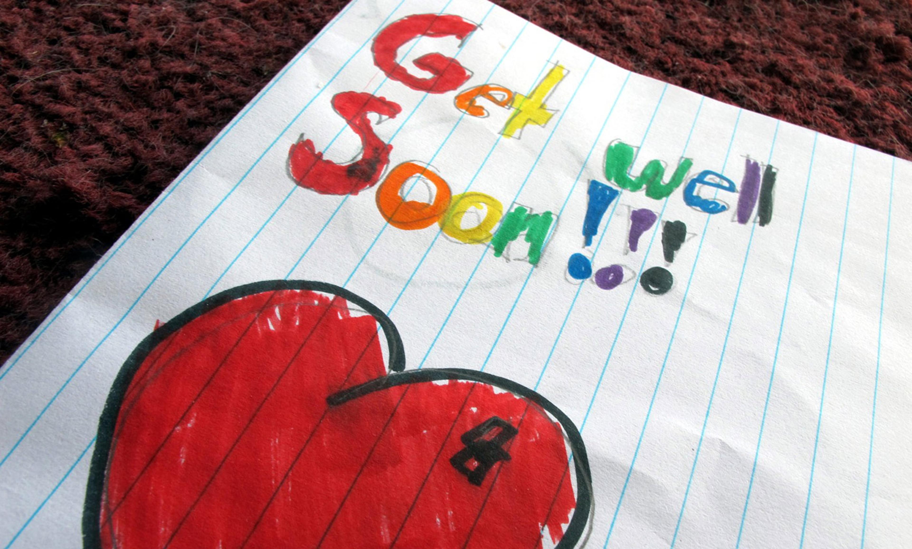 A hand-drawn ‘Get Well Soon’ card on lined paper, with colourful letters and a large red heart at the bottom.