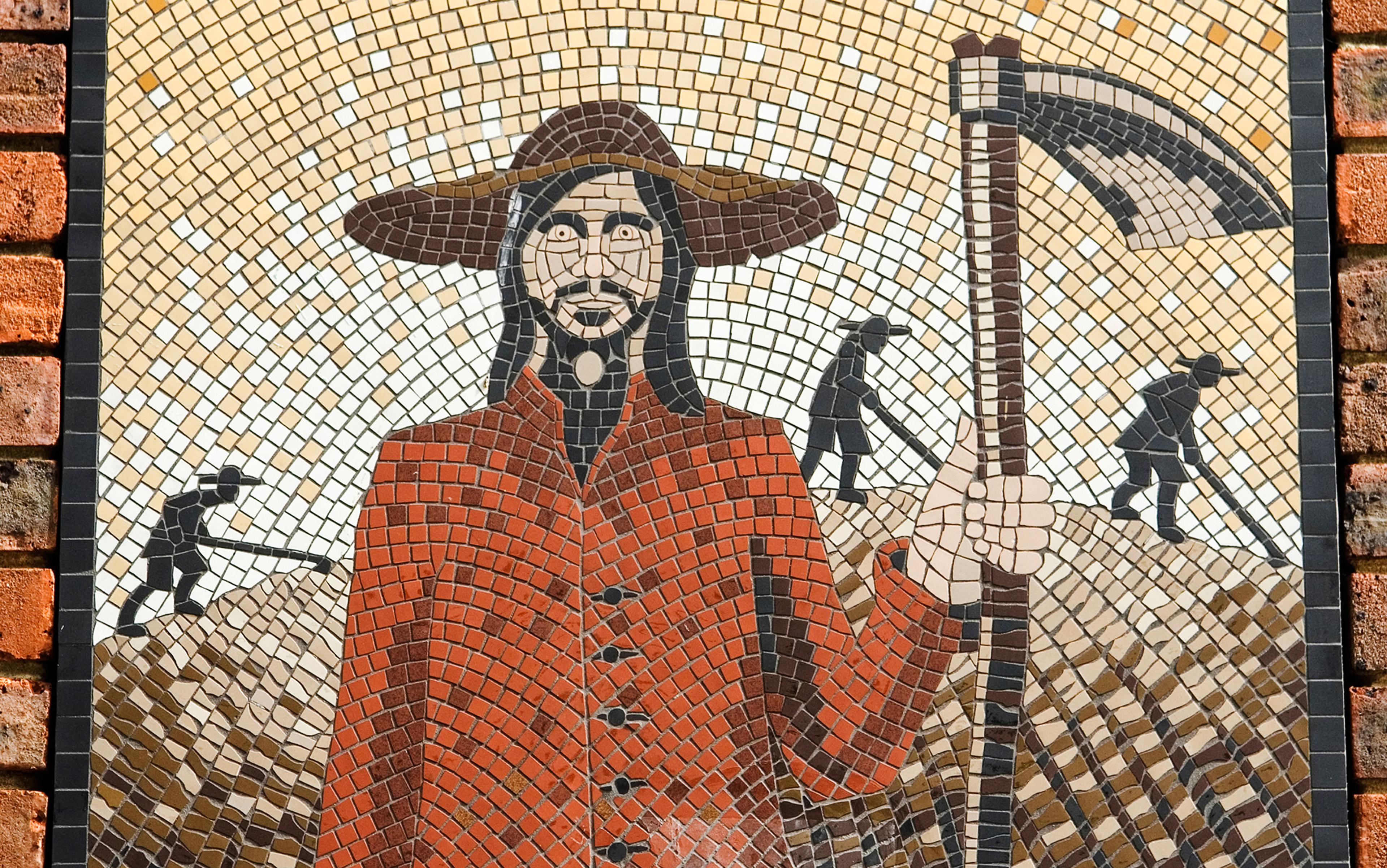 Mosaic of a man in a red coat and wide brimmed hat holding a scythe with three workers in the background on a patterned brick wall.