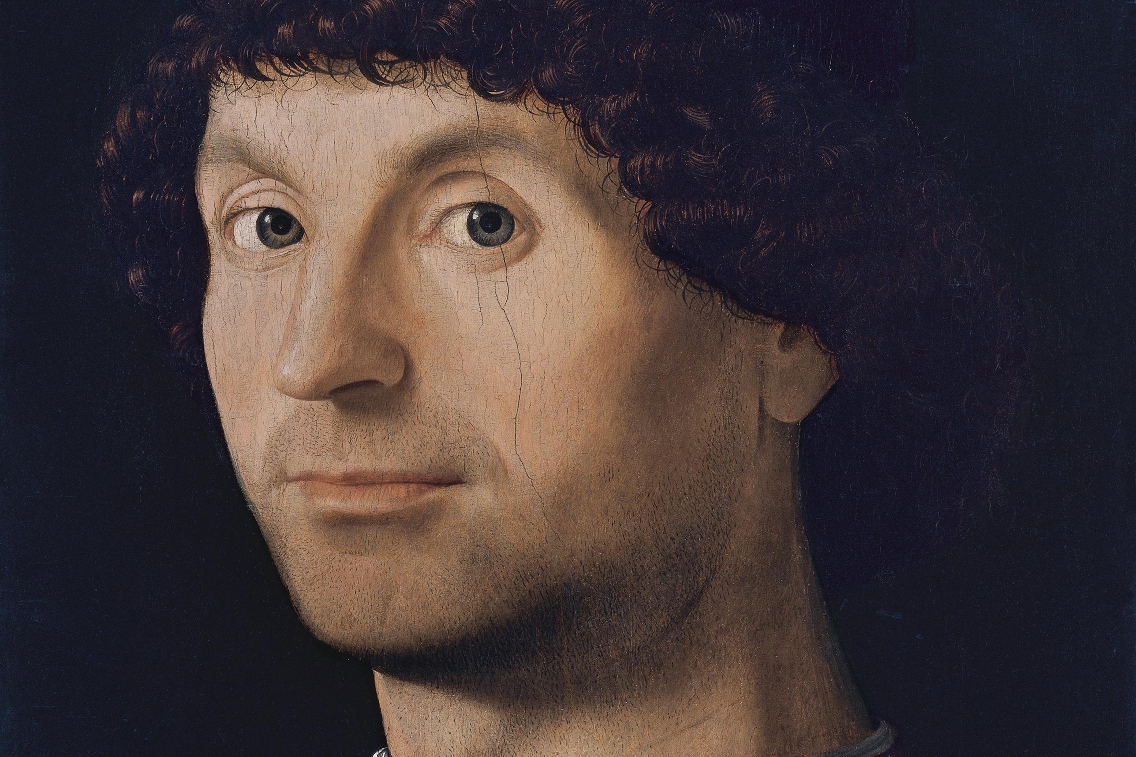 Renaissance painting of a man with curly hair wearing a dark hat and clothing against a dark background.