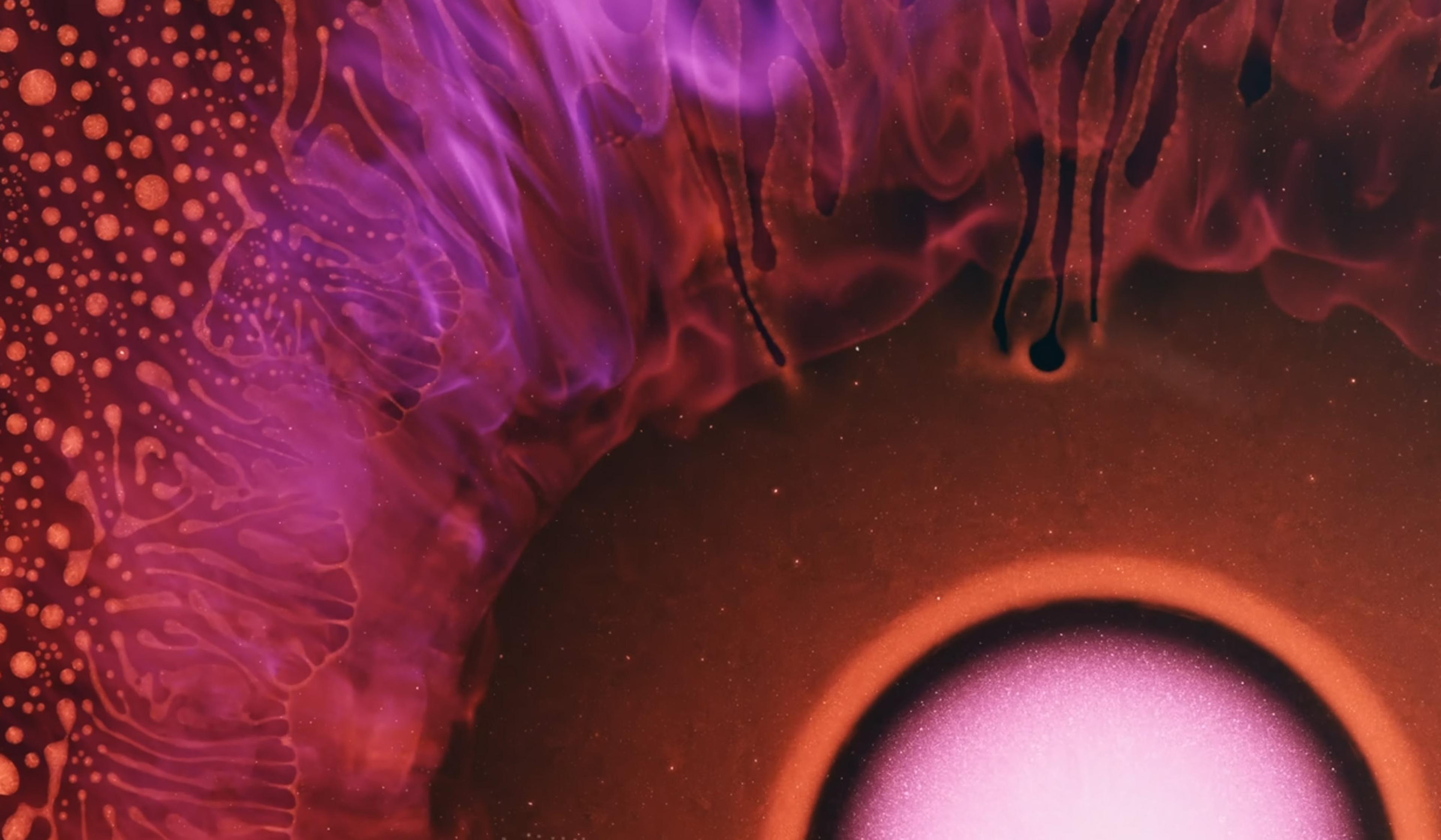Abstract image with a vibrant pink and purple swirling pattern, featuring a glowing orb in the lower right corner and organic, fluid shapes around it.