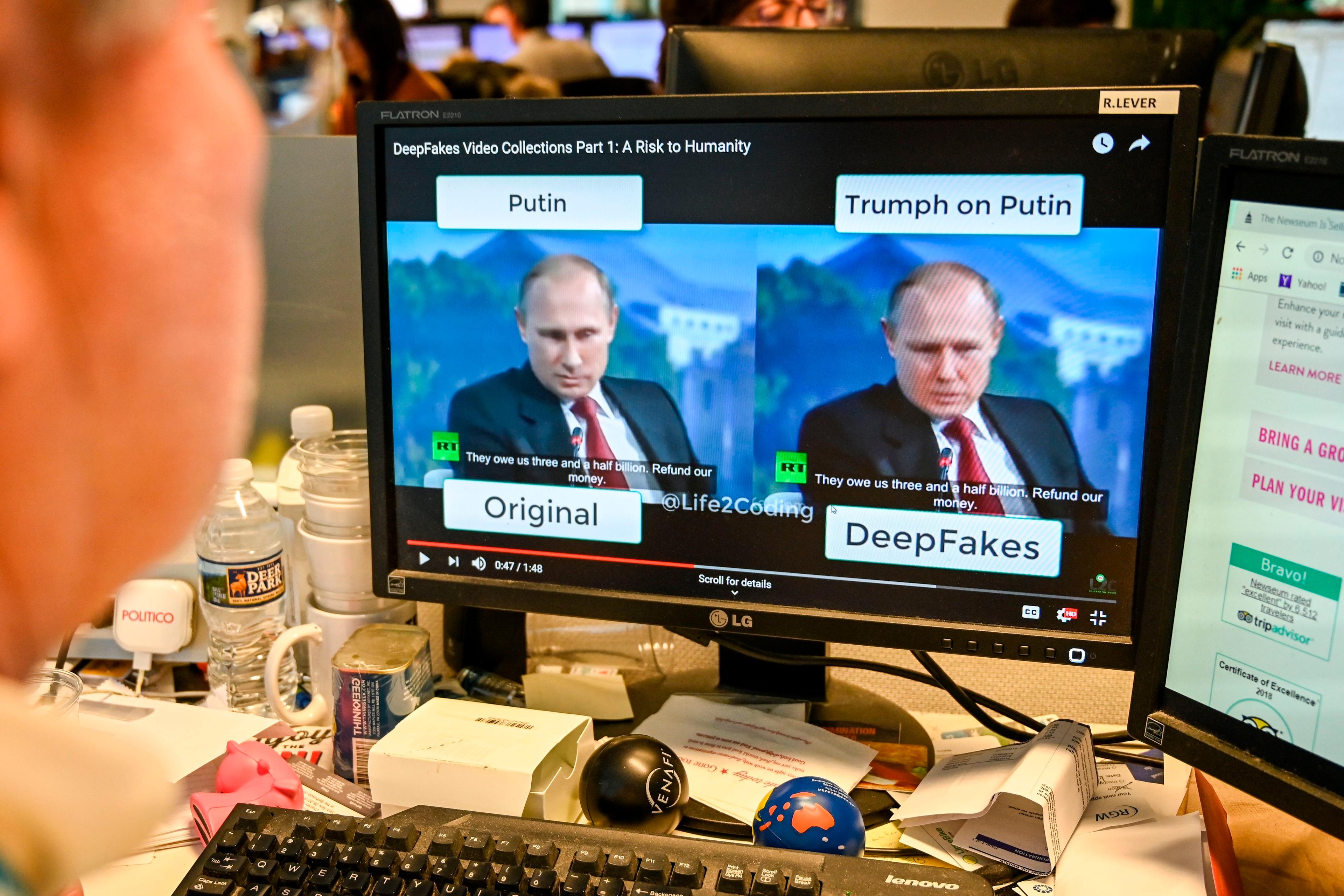 Photo of a computer screen showing a deepfake video comparison with original content on a cluttered desk.