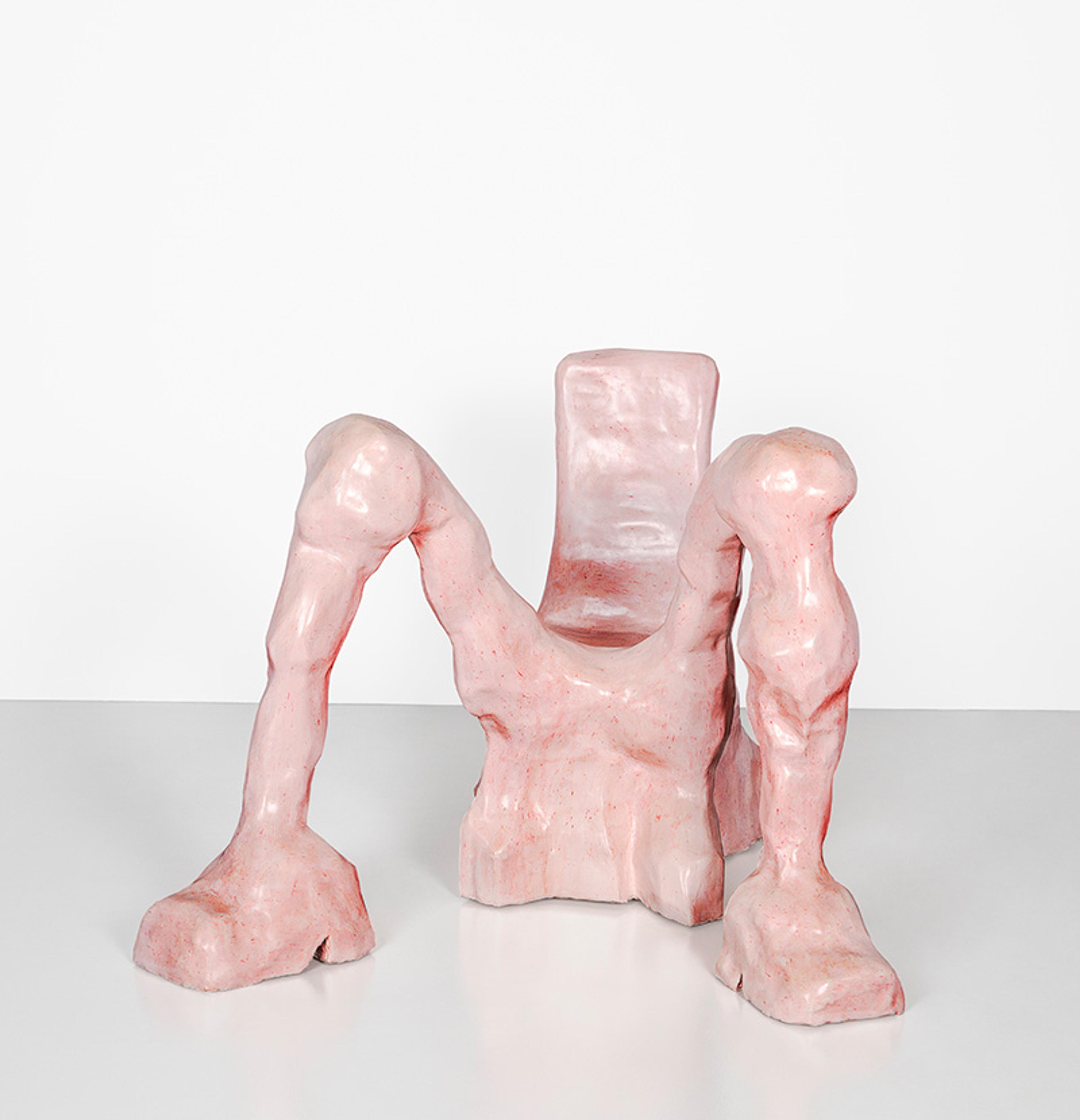 Sculpture of a pale-pink abstract chair with leg-like supports, placed on a white surface against a plain white background.