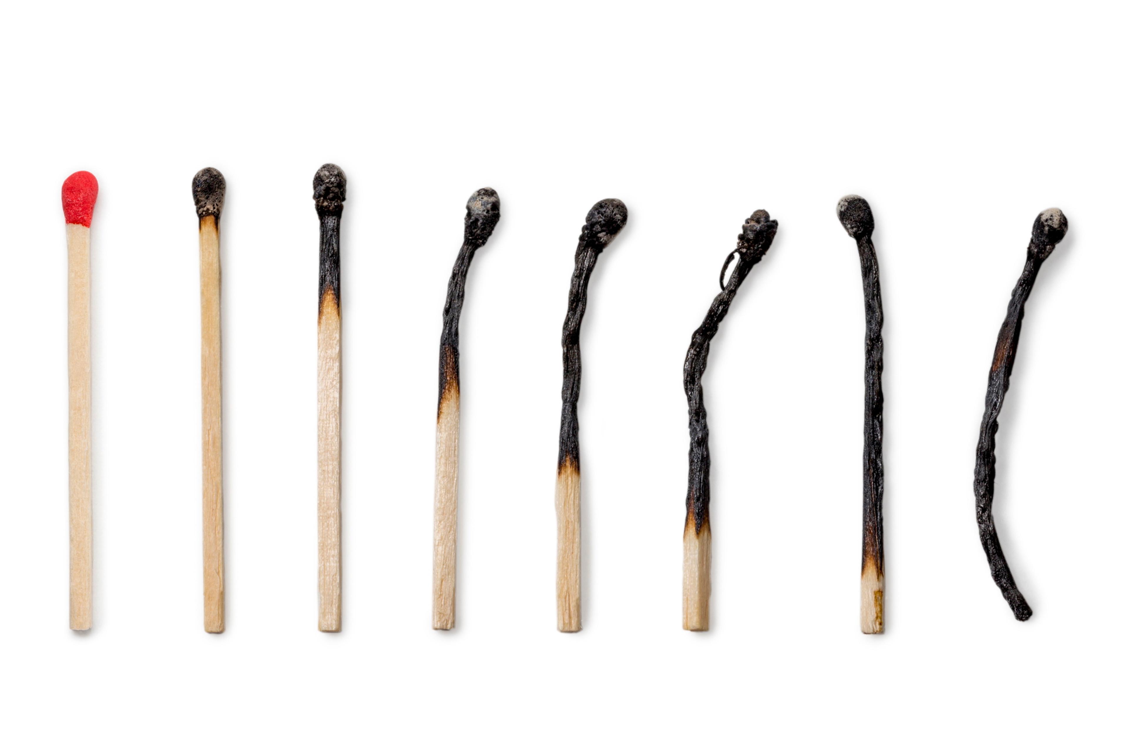 Photo of nine matches in a row, progressing from unused to completely burnt.