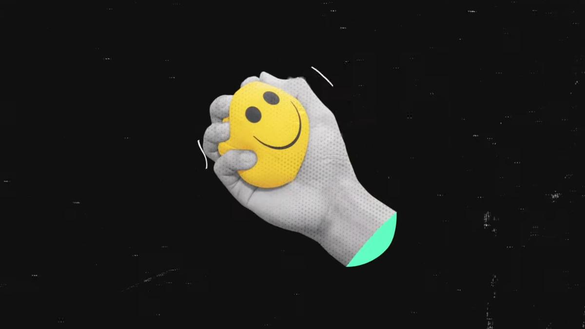Digital artwork of a grey hand squeezing a yellow stress ball with a smiley face on a black background.