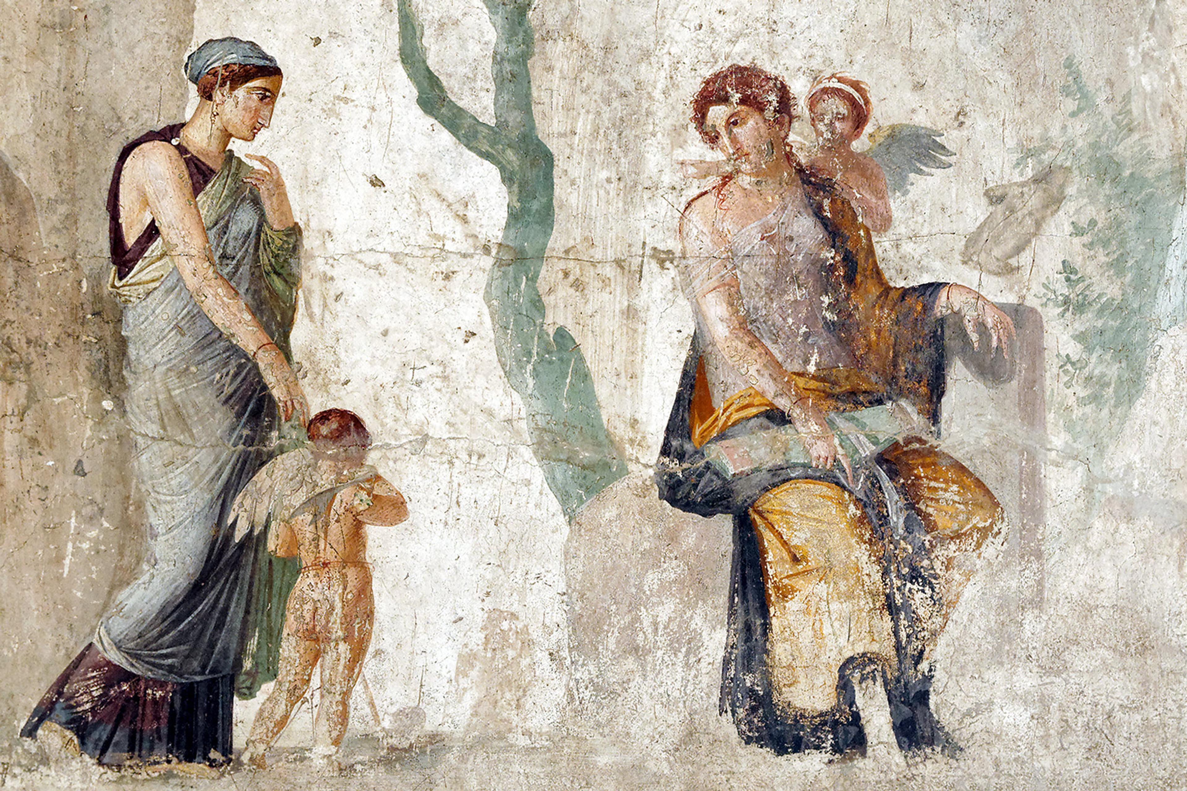 Ancient fresco depicts a seated figure holding a child, while another figure approaches, accompanied by a young child with wings, on a weathered background.