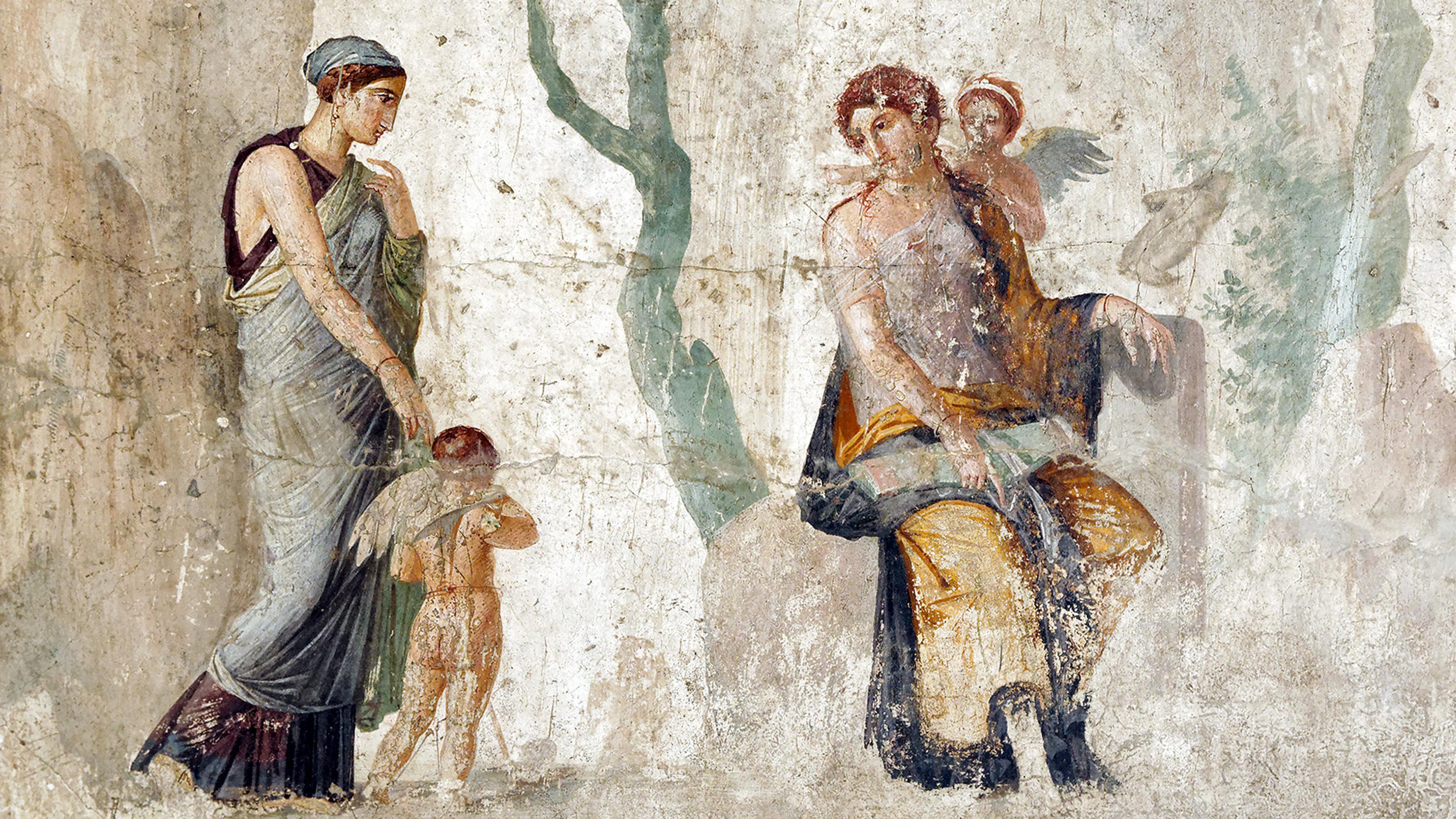 Ancient fresco depicts a seated figure holding a child, while another figure approaches, accompanied by a young child with wings, on a weathered background.