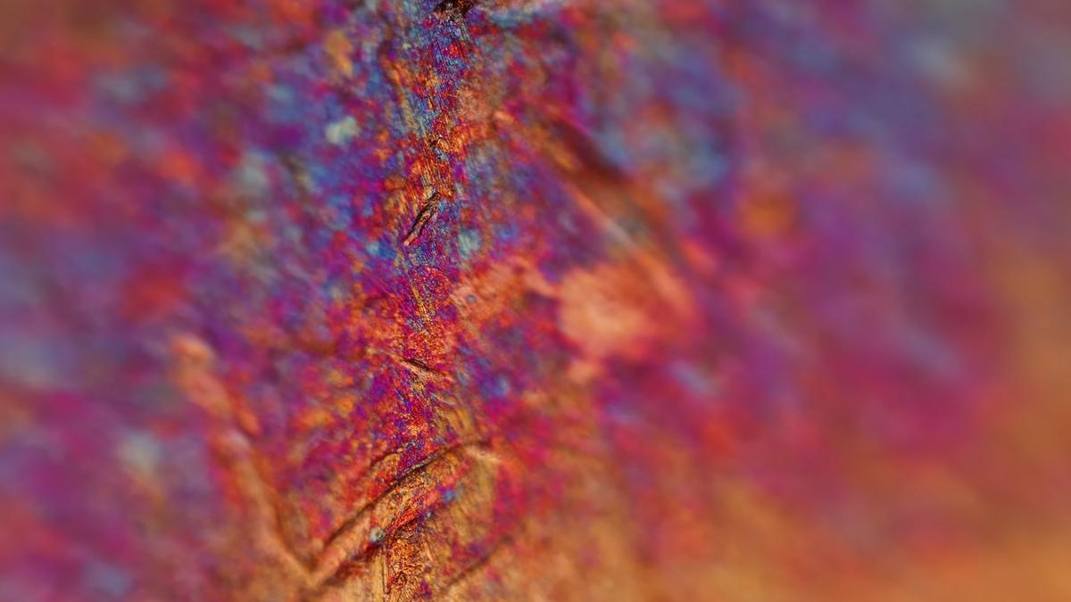 Close-up photo of a textured surface with vibrant purple, orange and blue abstract patterns.