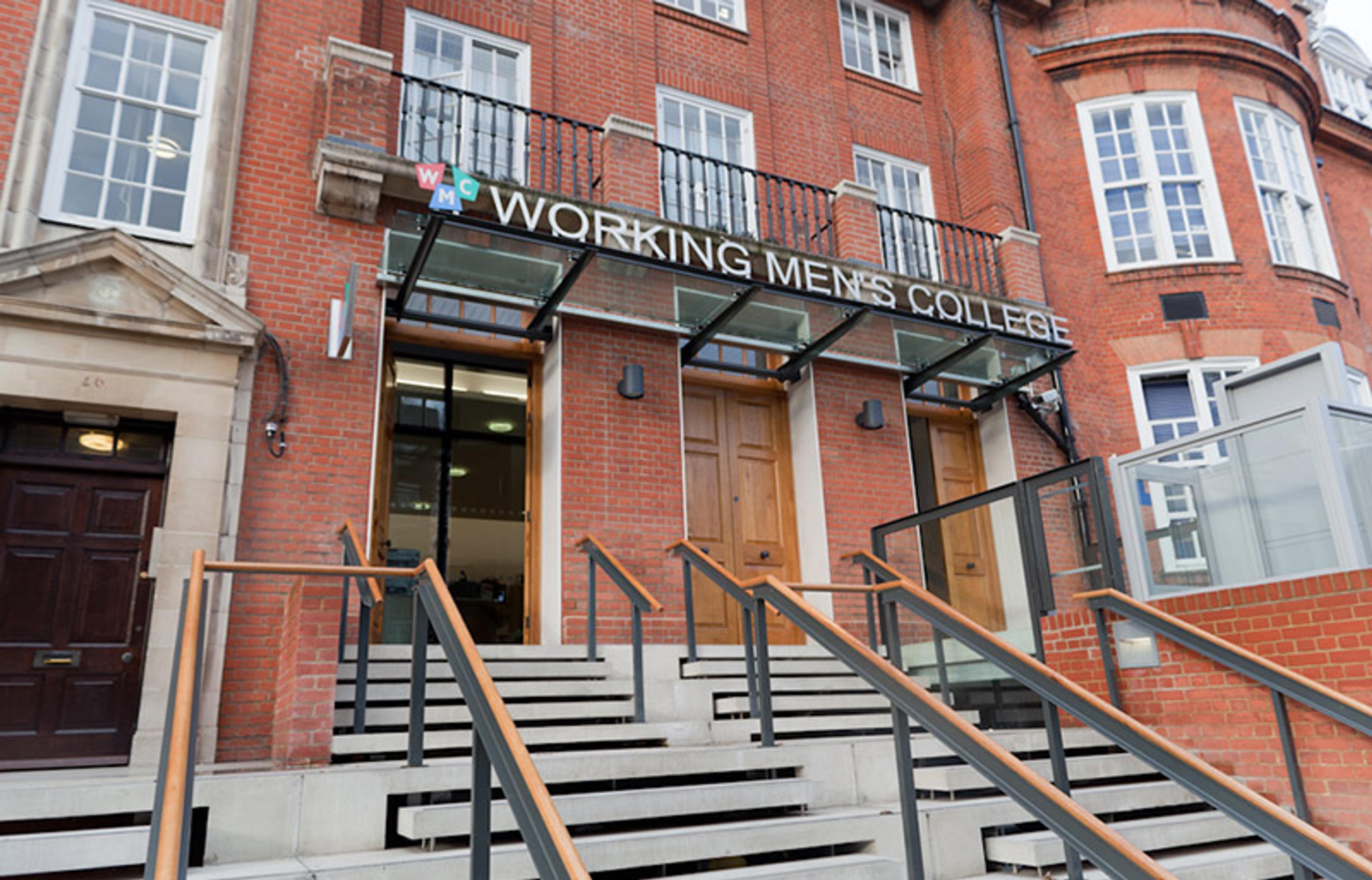 The entrance to Working Men’s College, showing red brick exterior, glass canopy and steps with handrails.