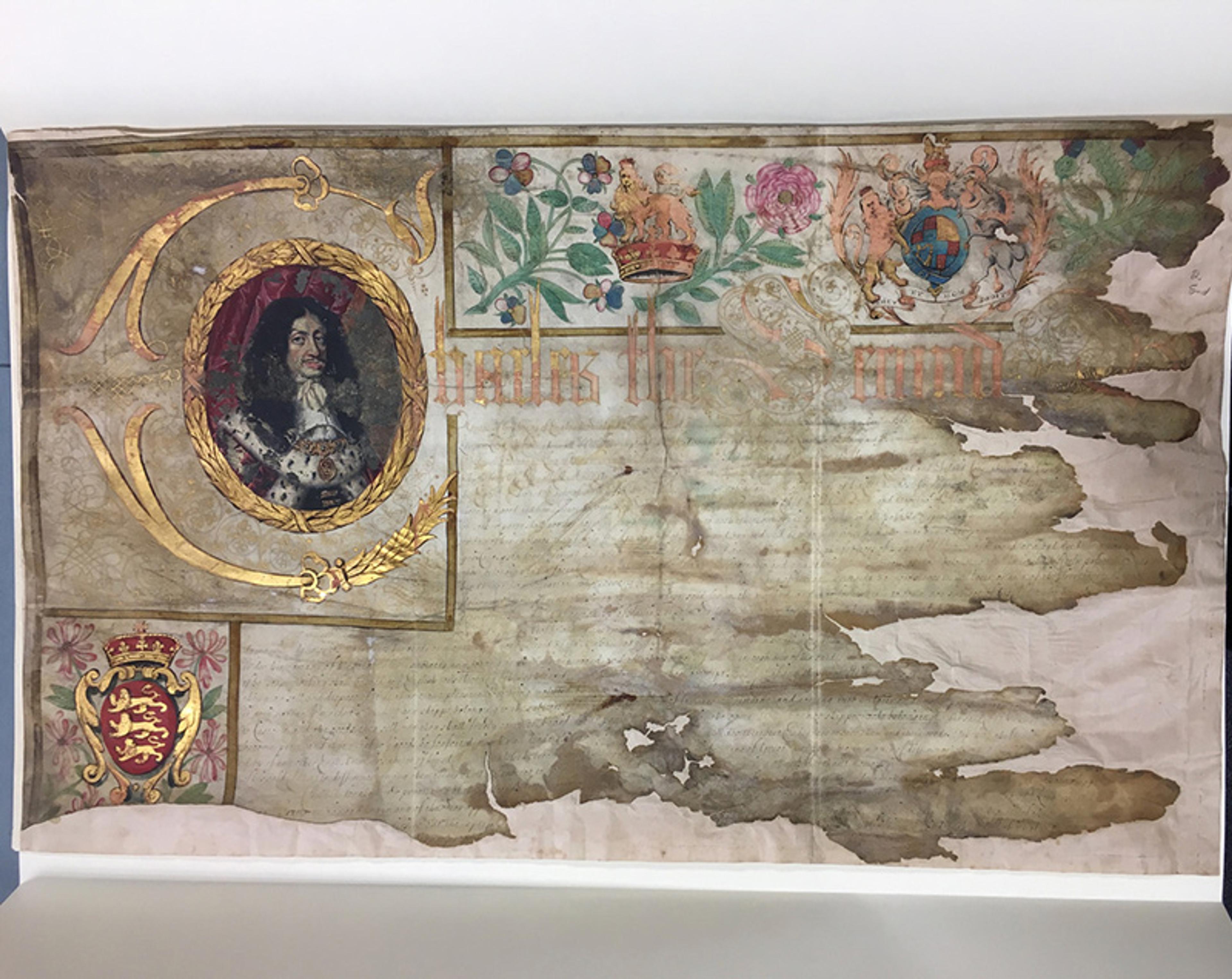 A photo of an aged, partially damaged parchment featuring a portrait, floral illustrations and faded text.