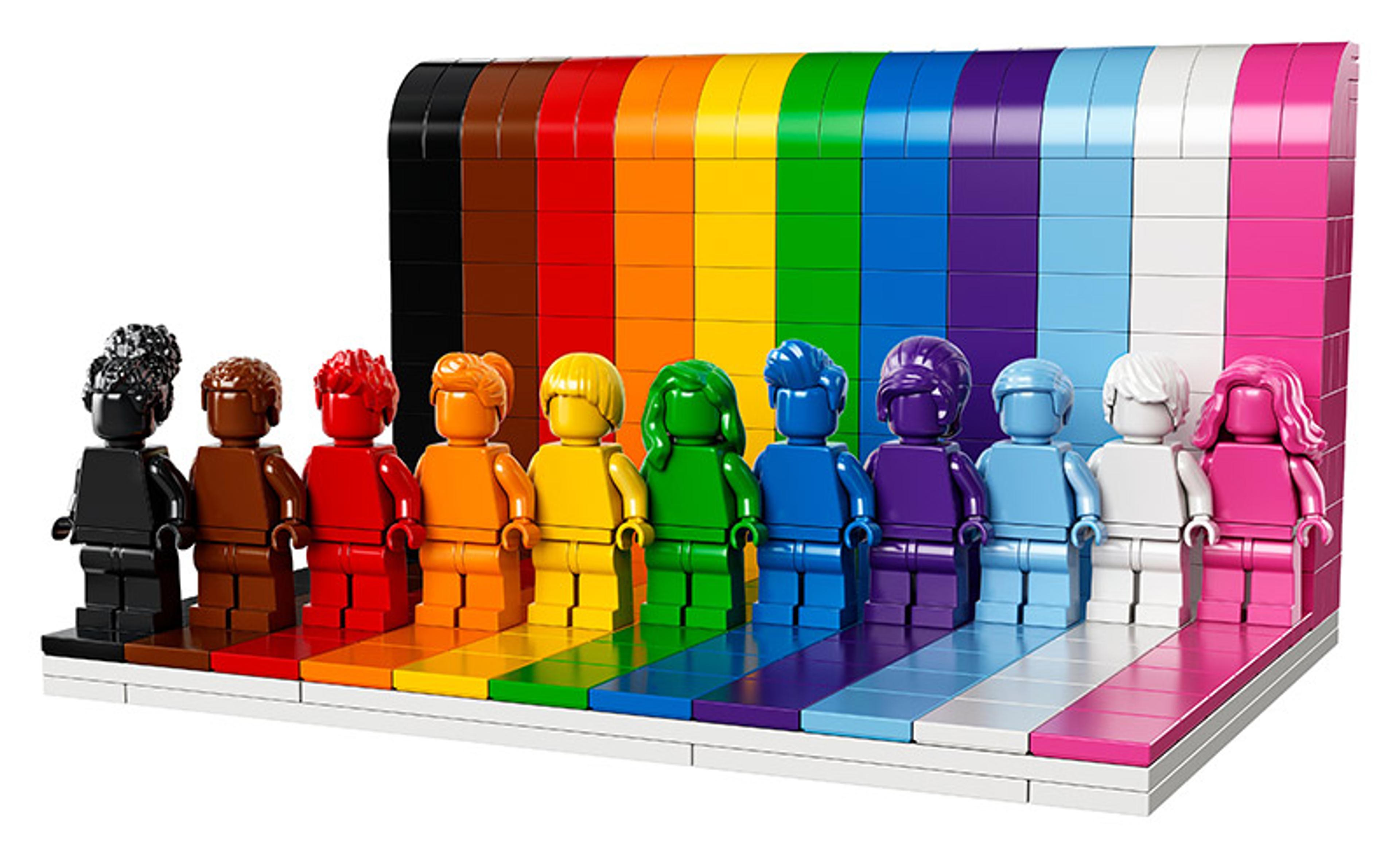 LEGO minifigures in various colours standing in front of matching tiles, arranged in a rainbow gradient from black to pink.