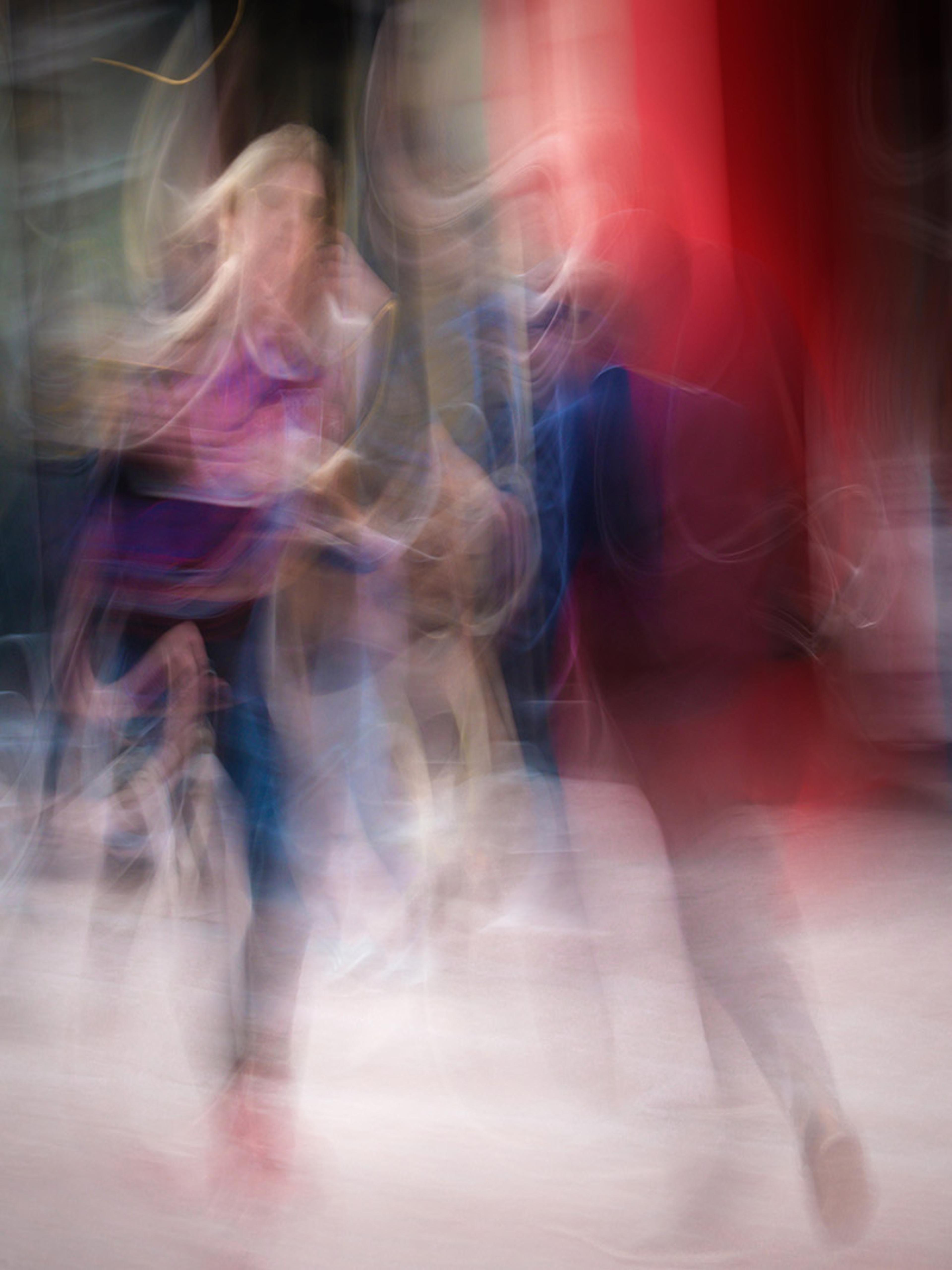 Two people blurred in motion with a mix of red, blue and black colours creating an abstract, dreamlike effect.