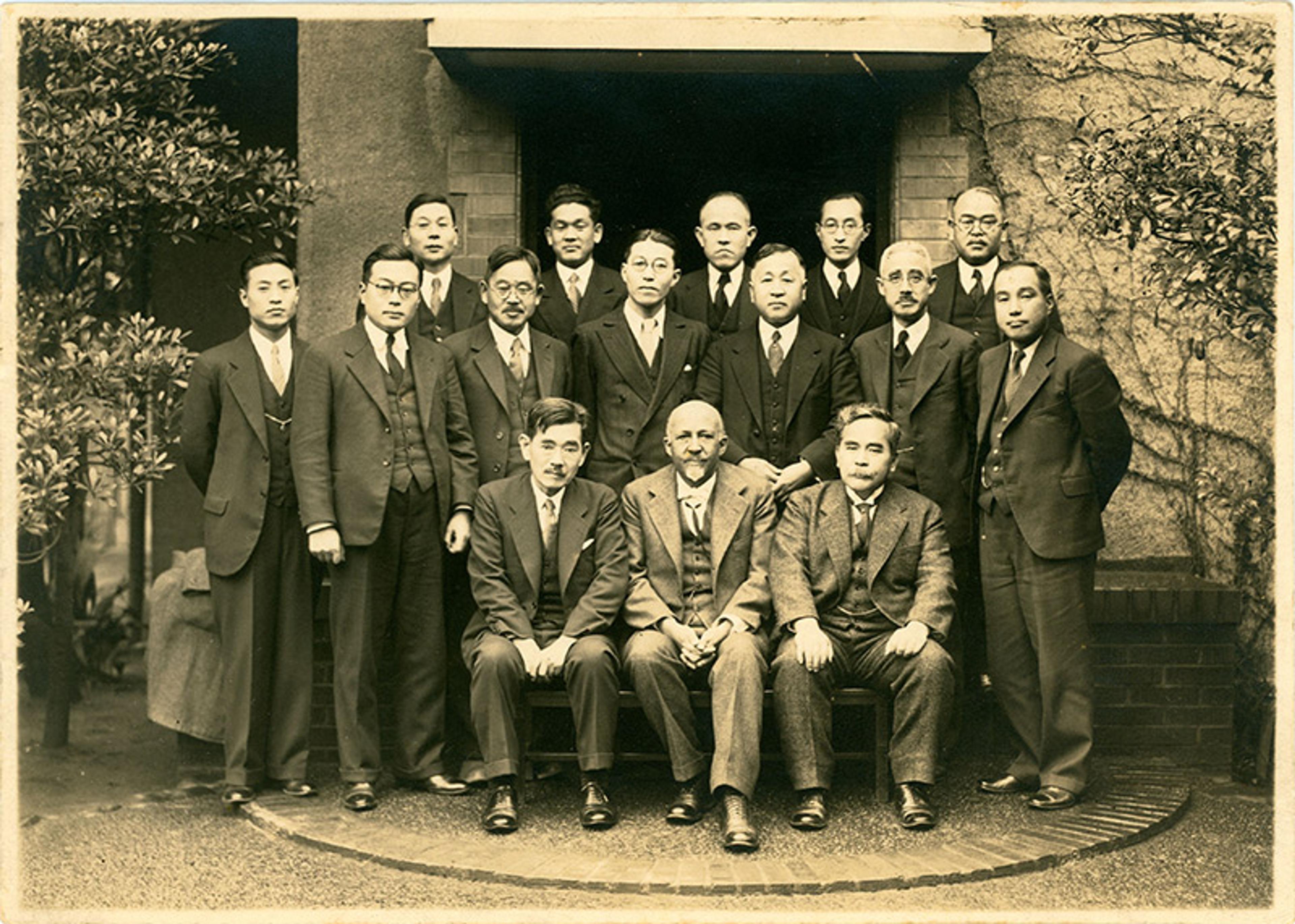A sepia photograph of a group of professors arranged in a formal pose.