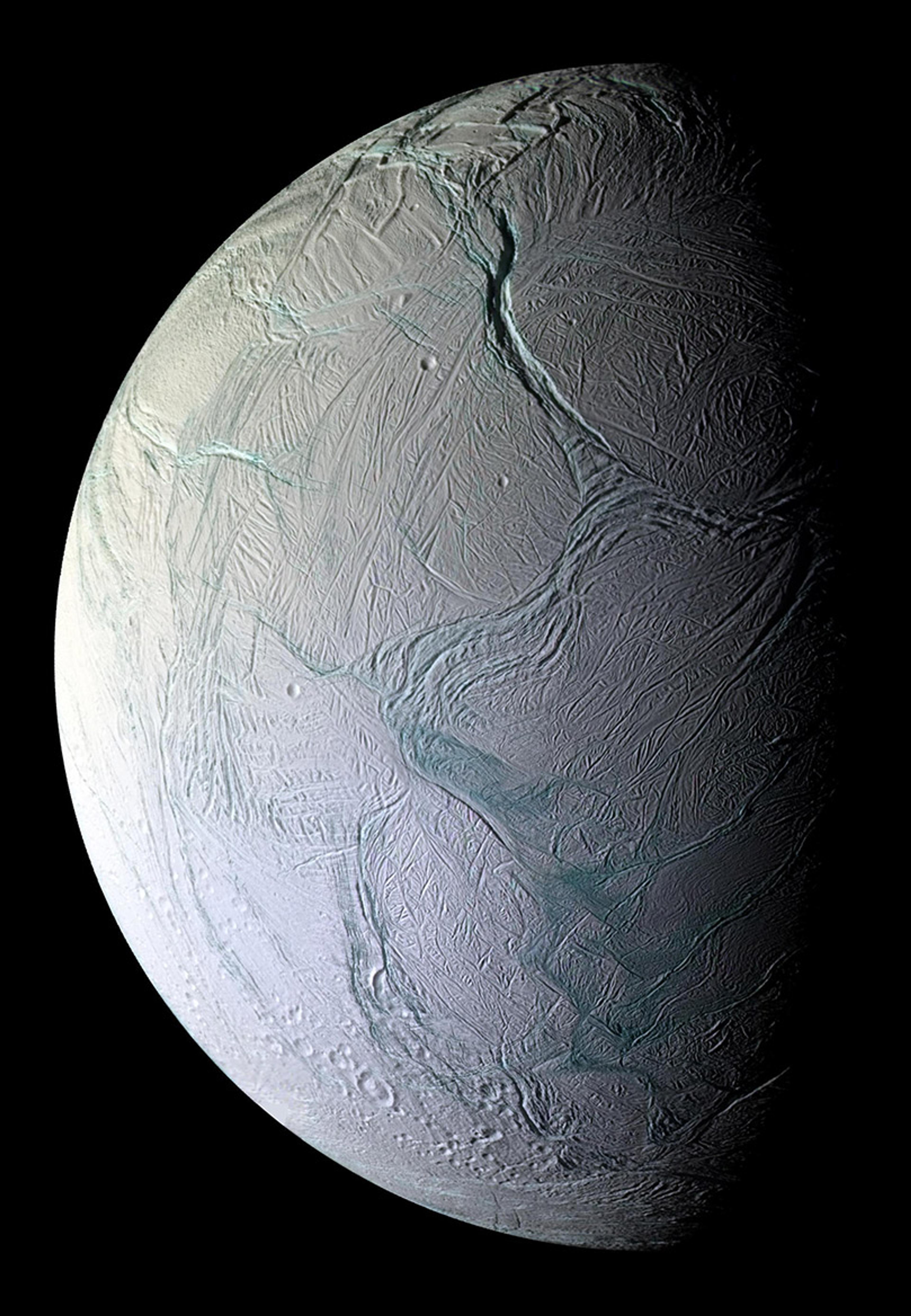 A half sphere of a heavily scarred moon surface in grey with patches of turquoise colour