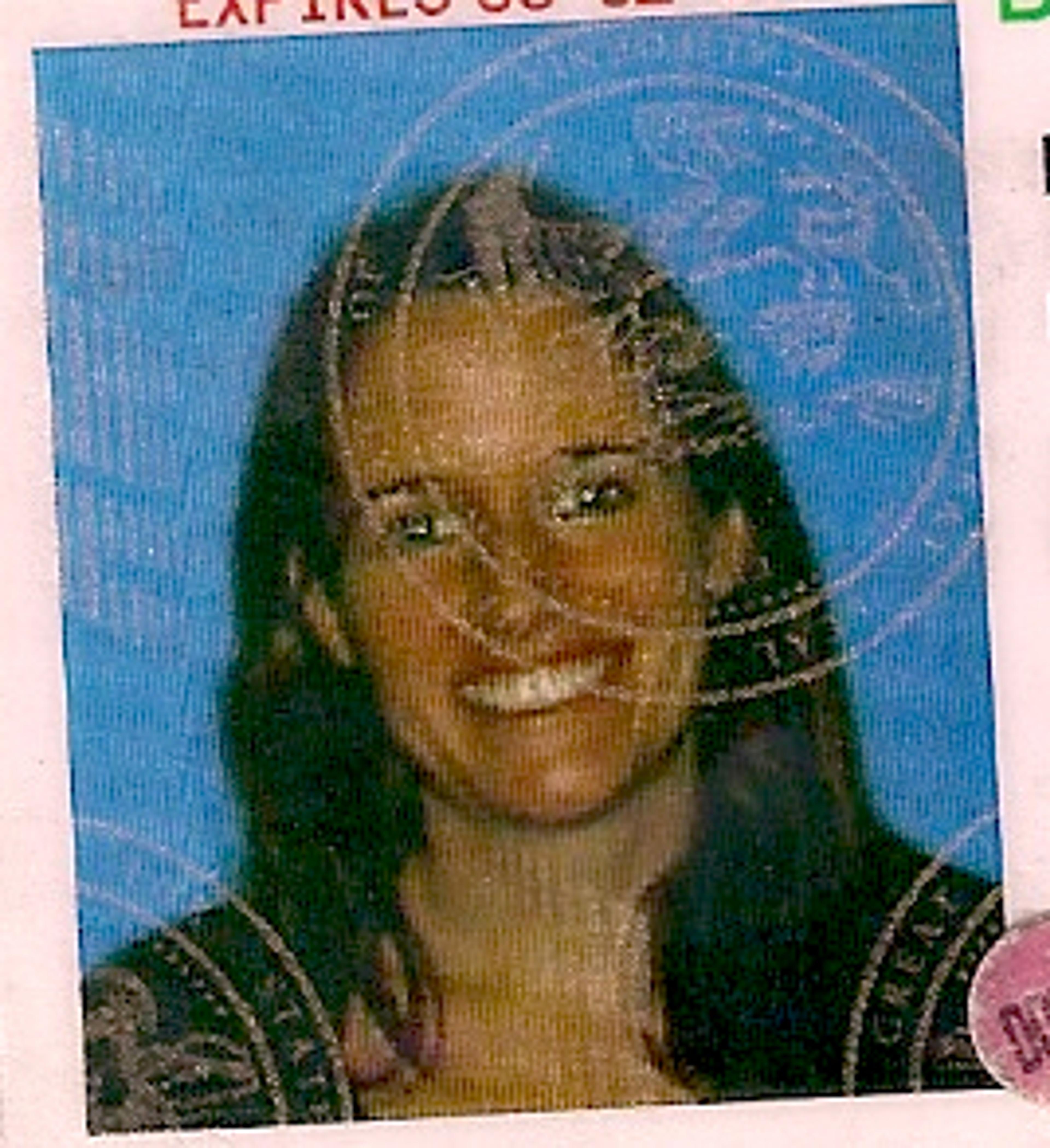 Photo of a woman smiling with long hair, used in a document with stamps over the image and a blue background.