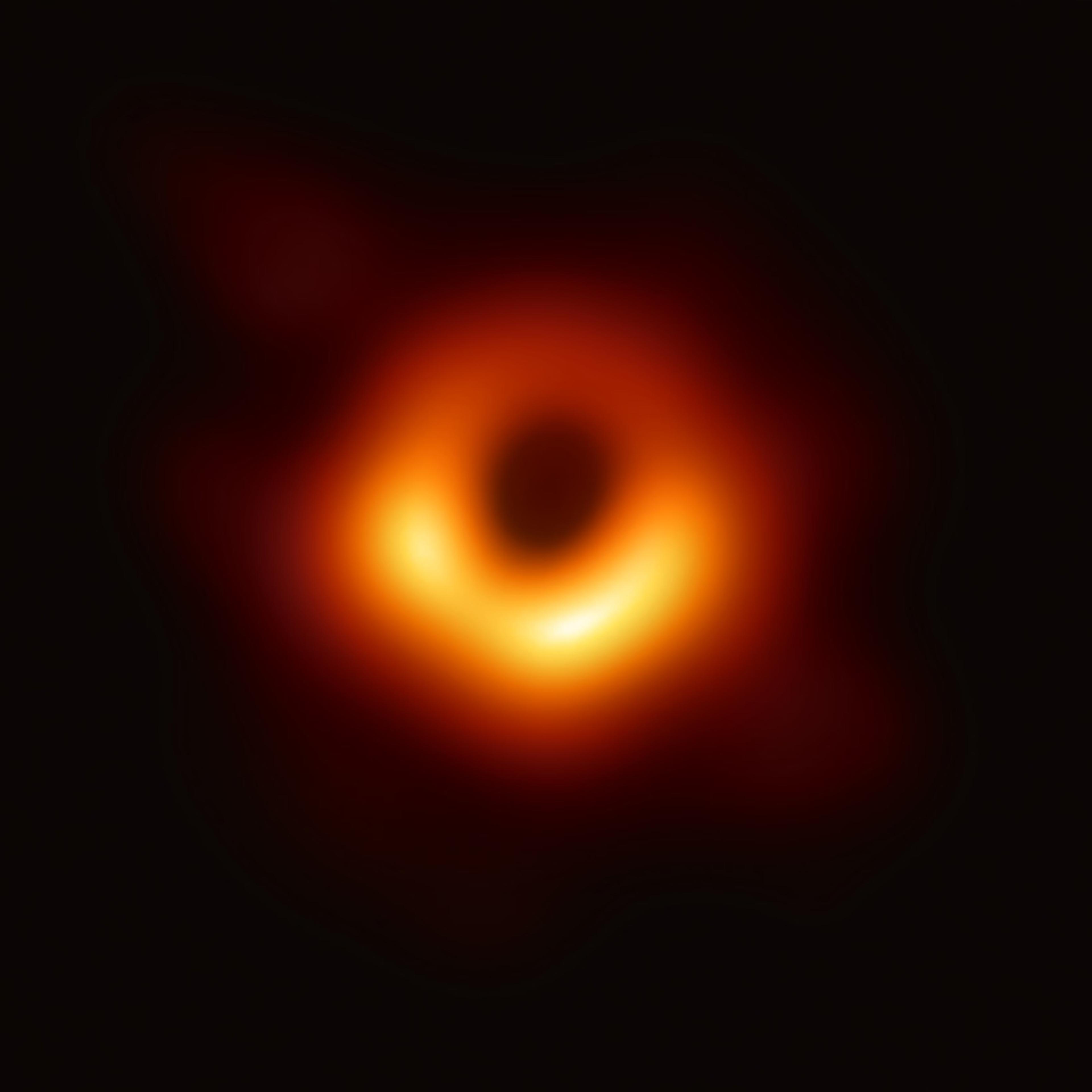 Image of a black hole photographed by the Event Horizon Telescope, featuring a glowing orange ring against a dark background.