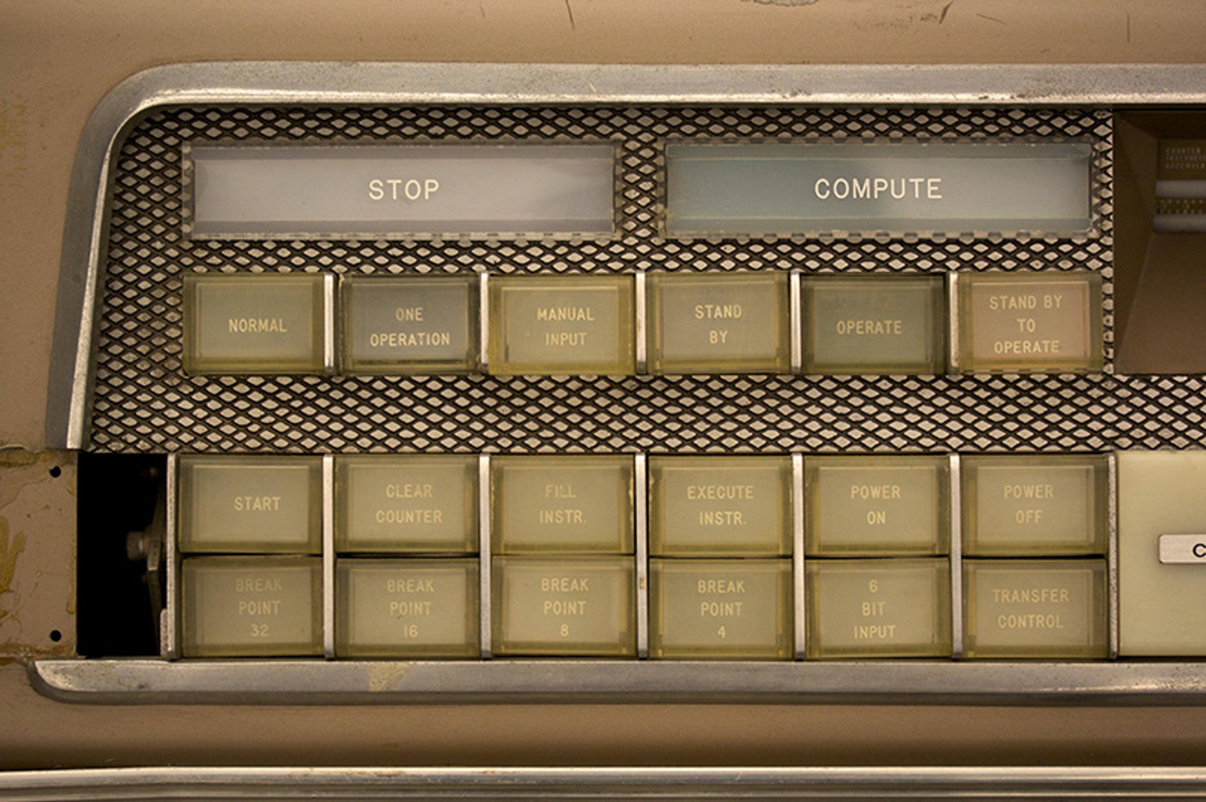 Close-up photo of a vintage computer control panel with buttons labelled for operations like “STOP”, “COMPUTE” and others.