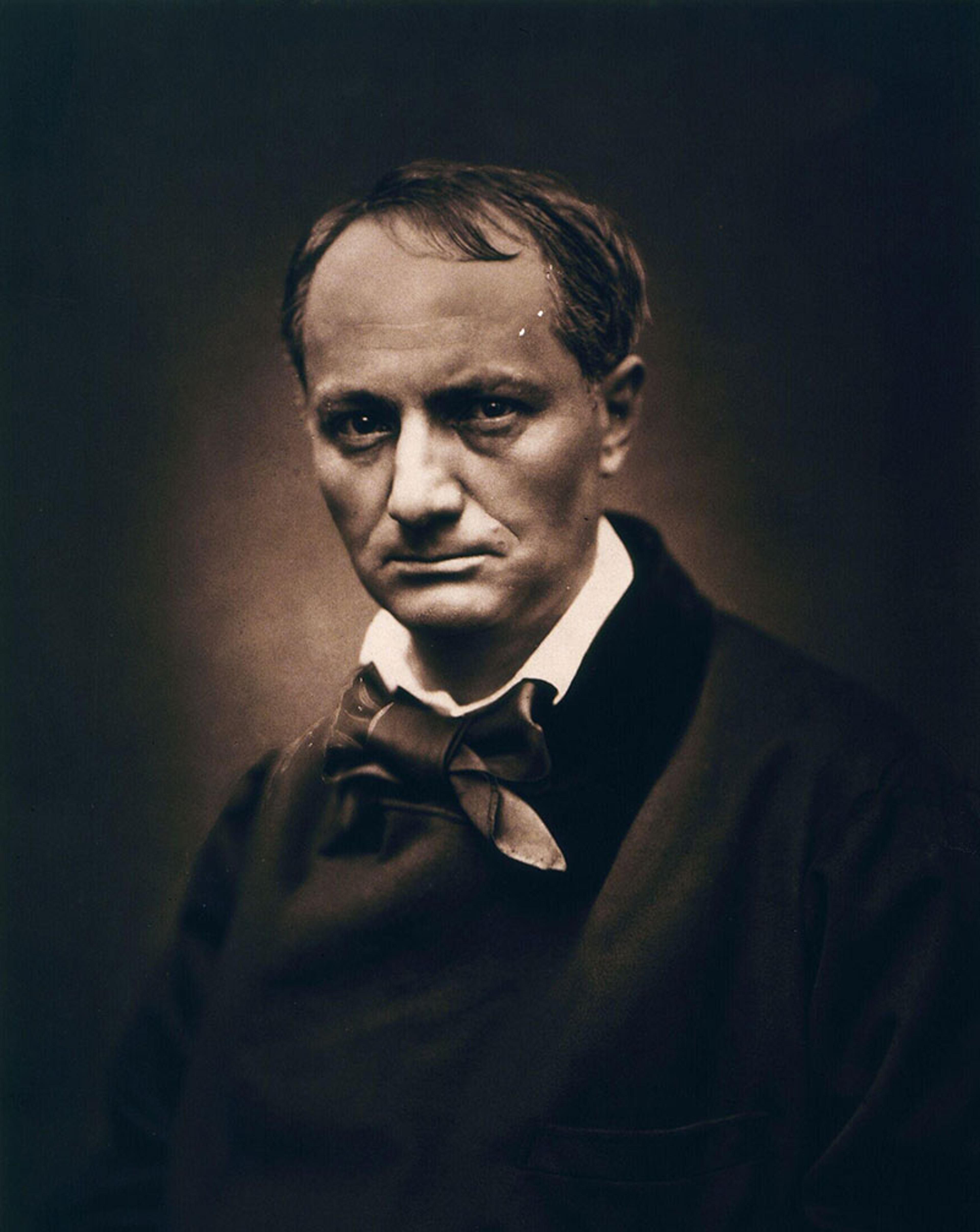 Sepia-toned portrait photo of a man in formal 19th-century attire with a neutral expression against a dark background.