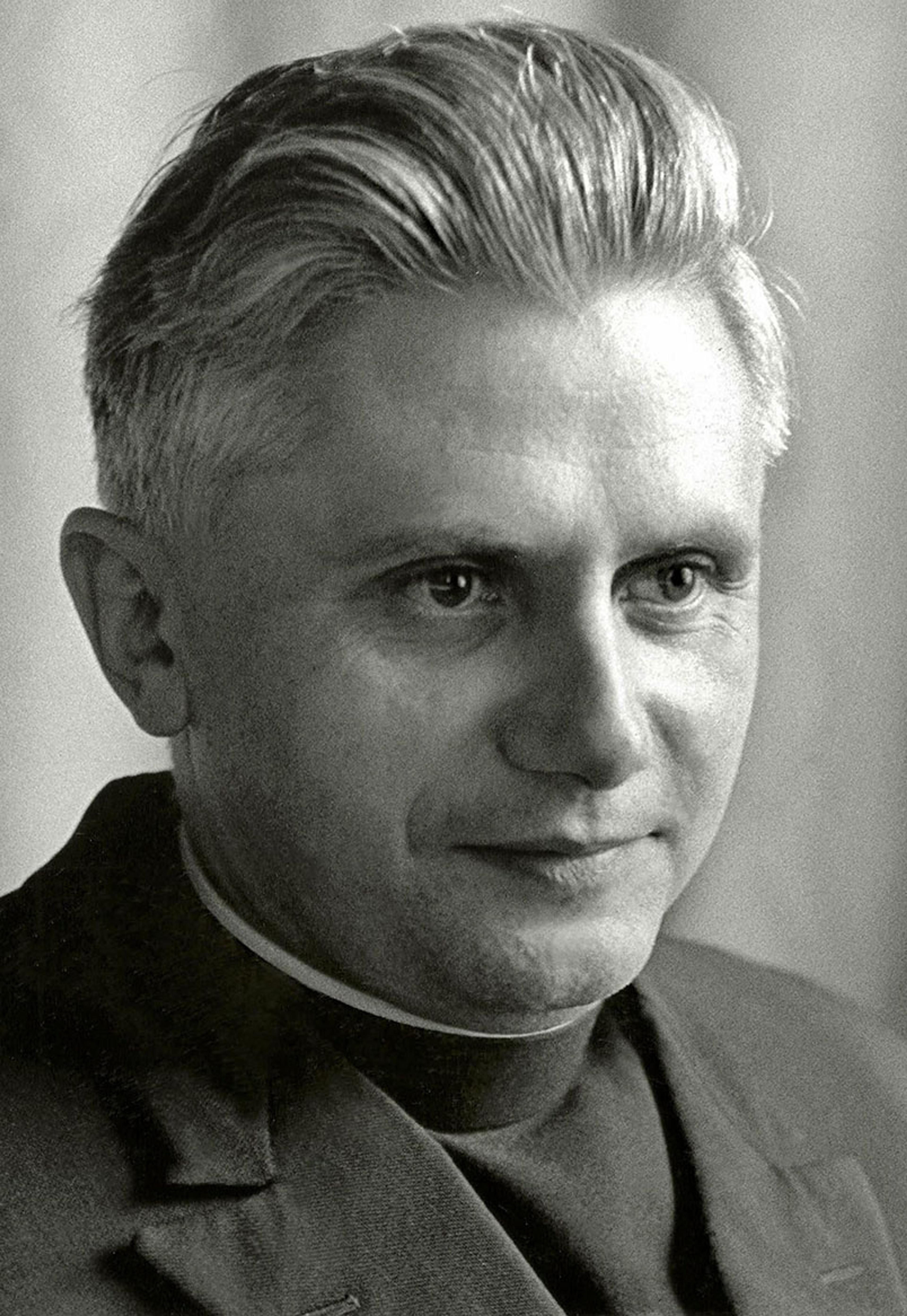 Black-and-white photo of a man wearing a clerical collar looking slightly to the side.