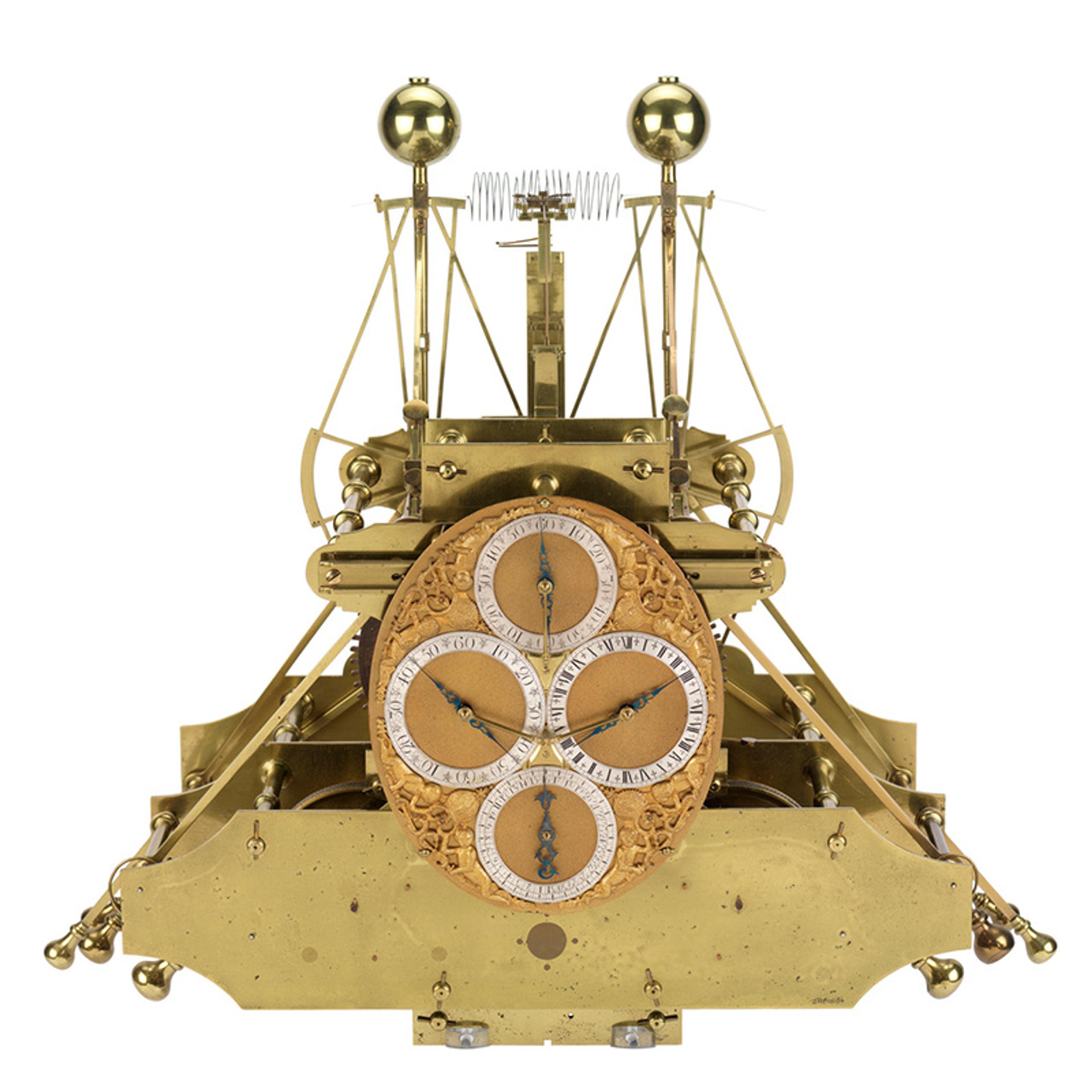 A complex brass mechanism with four clock faces, some featuring Roman or Arabic numerals and intricate detailing.