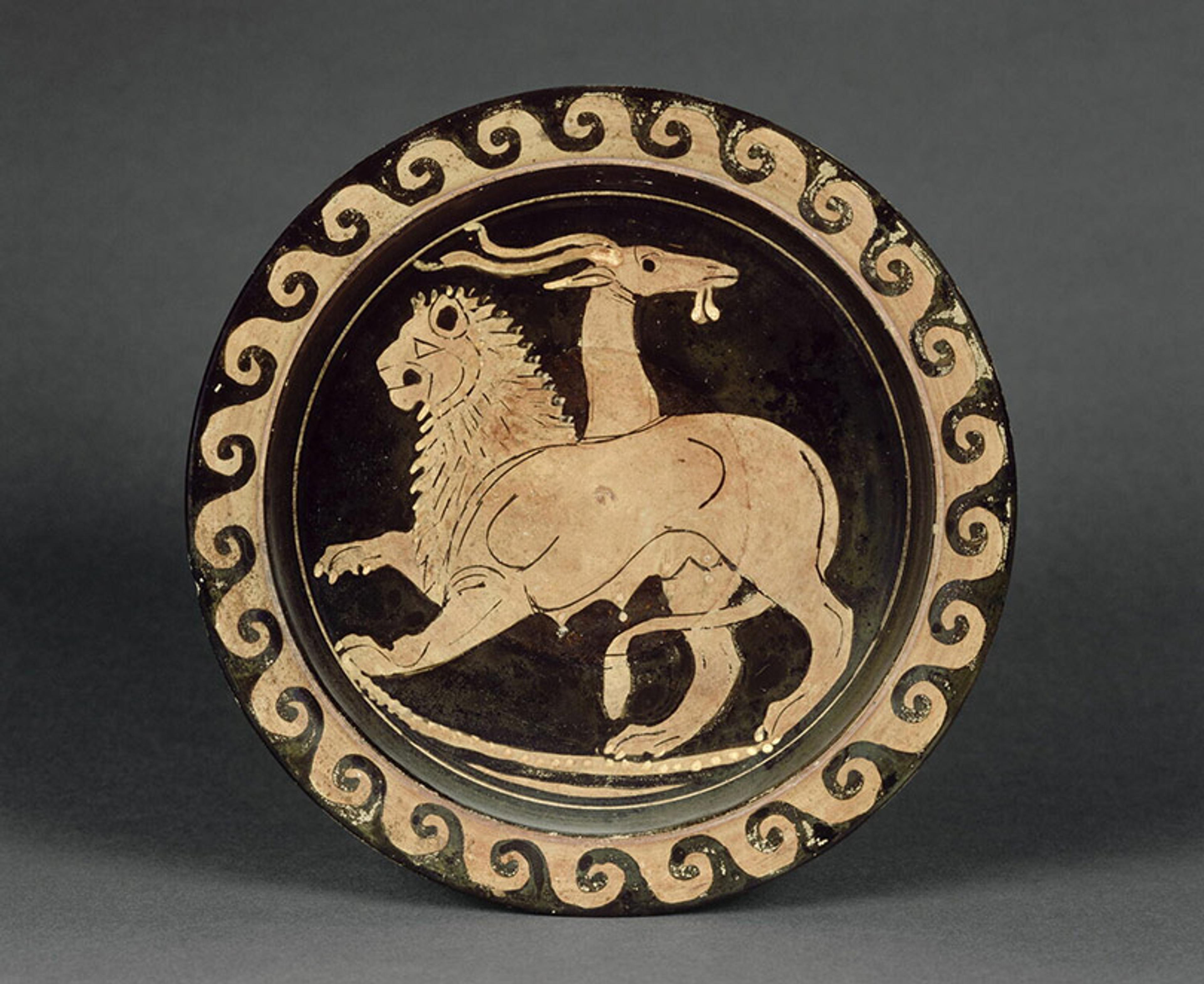 Ancient Greek pottery plate depicting a Chimera creature, featuring a lion, goat and serpent, with a geometric border design.