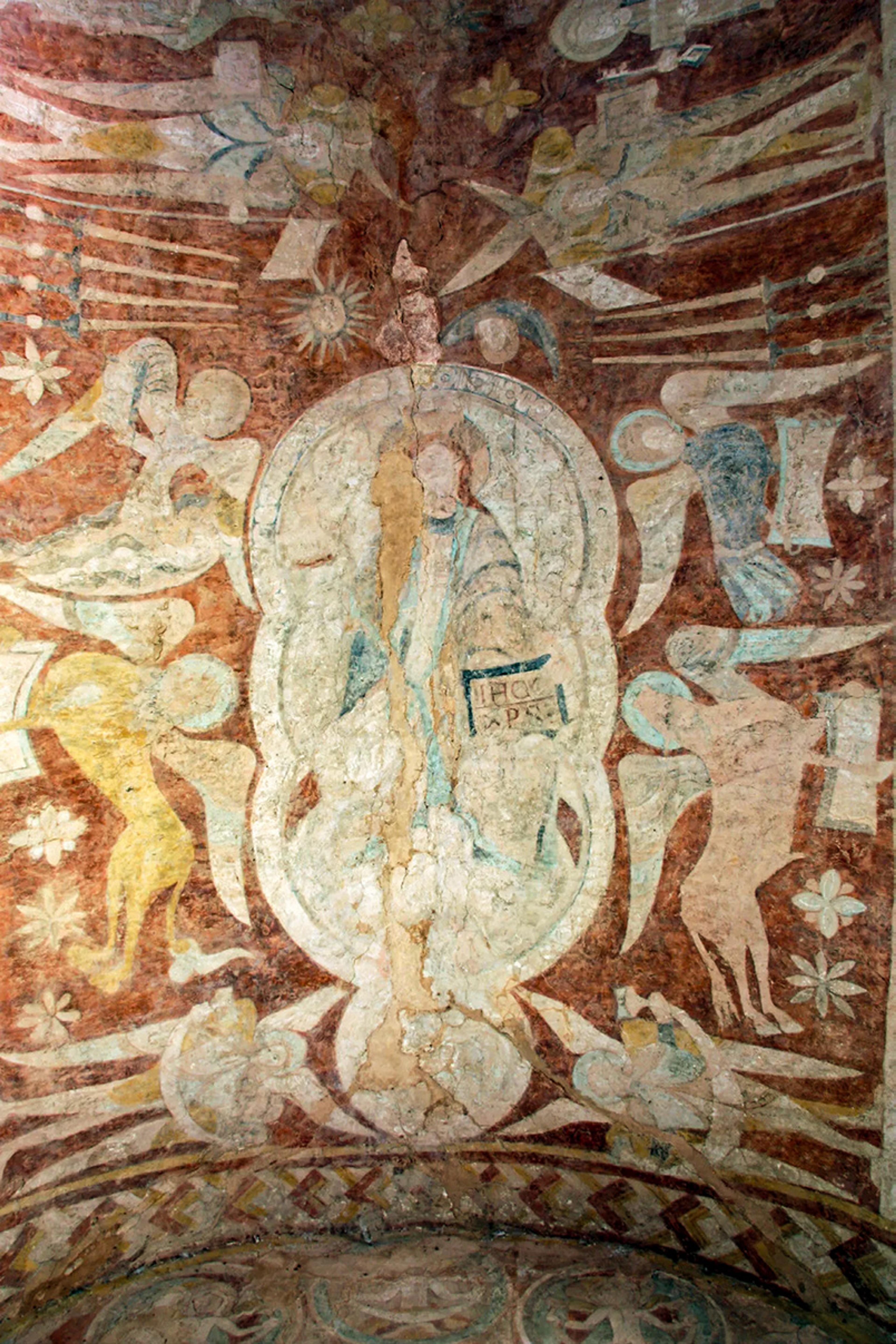 Fresco depicting a central figure surrounded by angels and celestial motifs on a weathered, earthy-toned background.