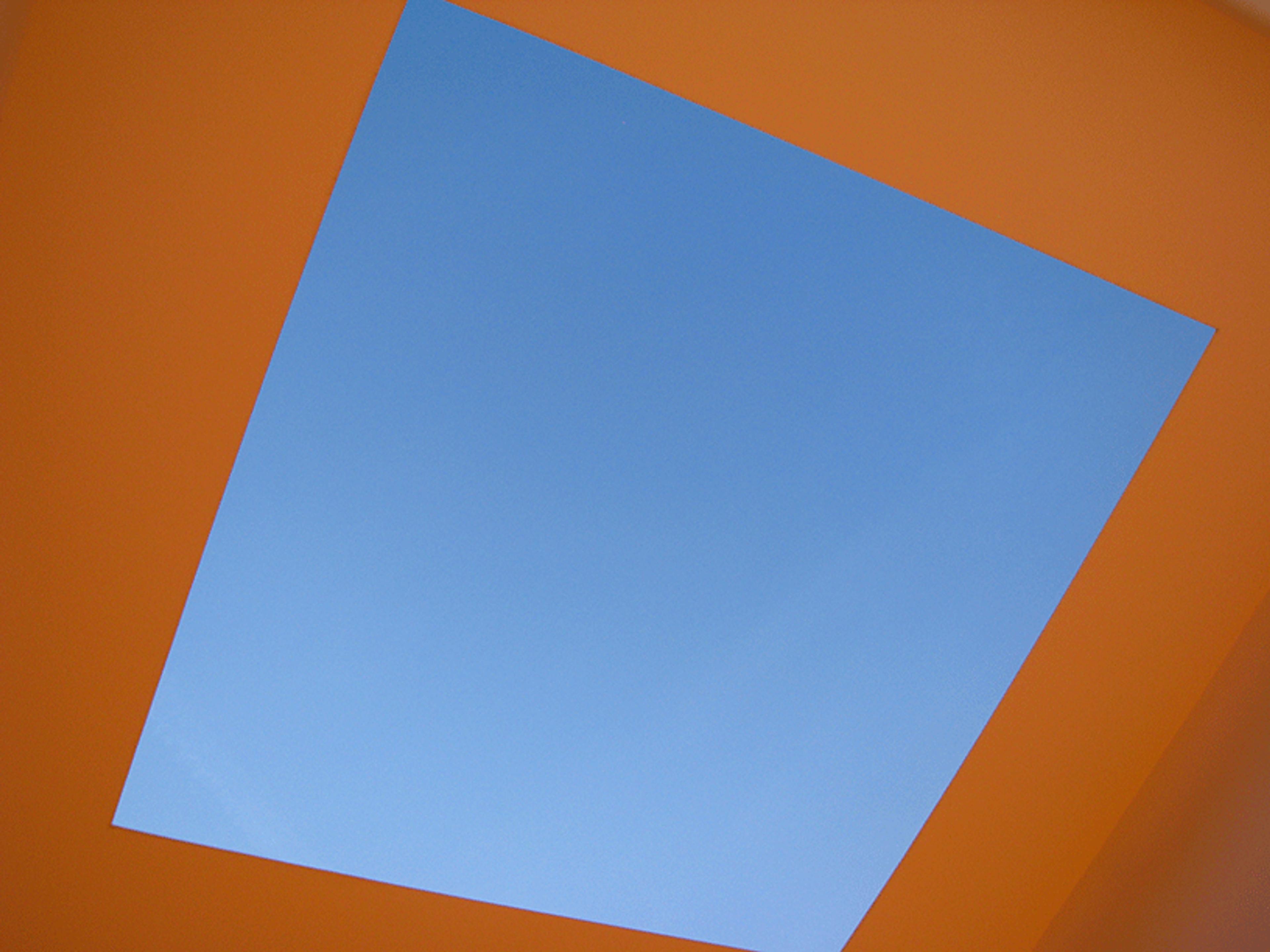 Photo of a bright blue sky framed by a square orange opening, viewed from below.