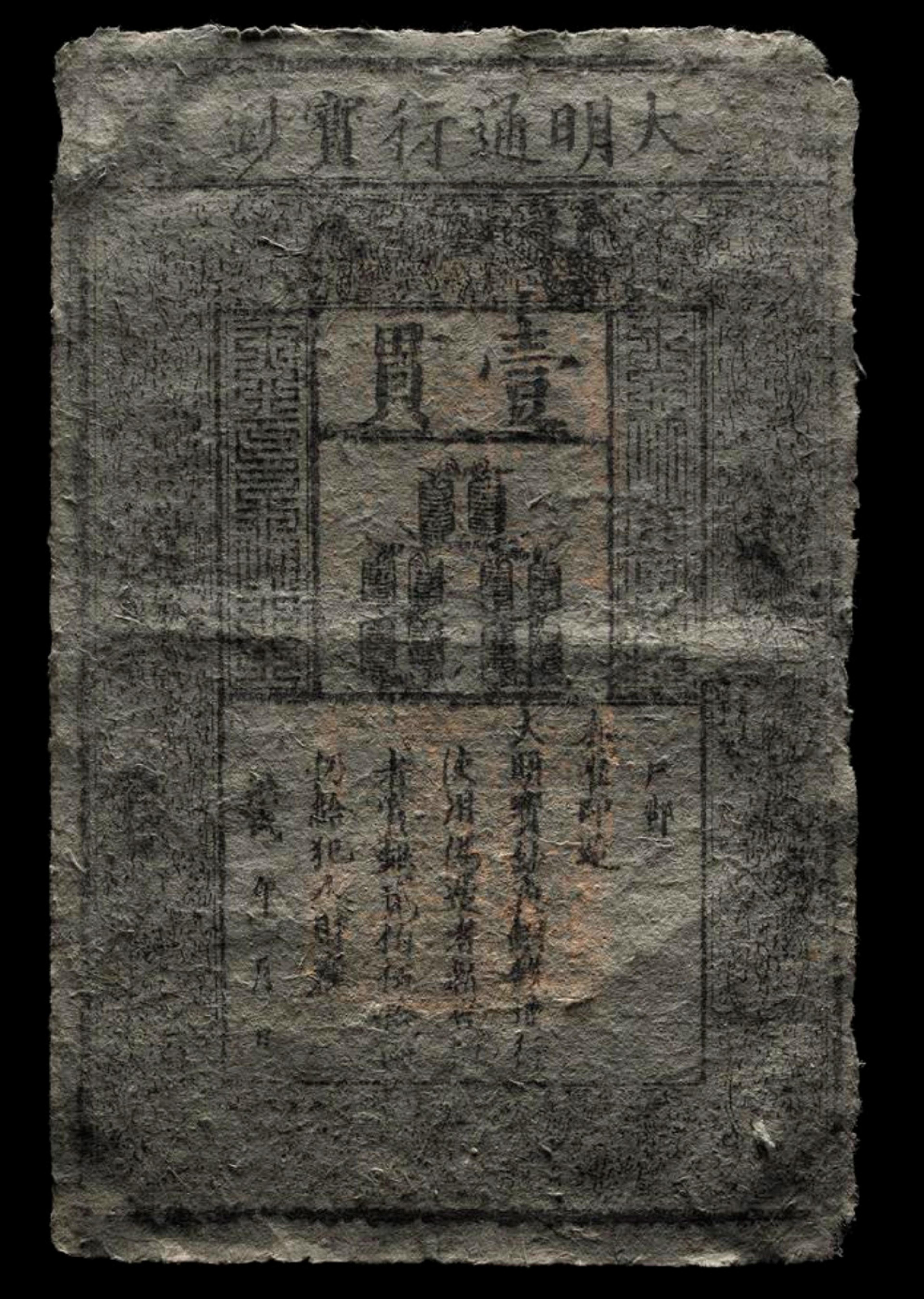 Ancient paper currency featuring Chinese characters, worn texture and intricate design.