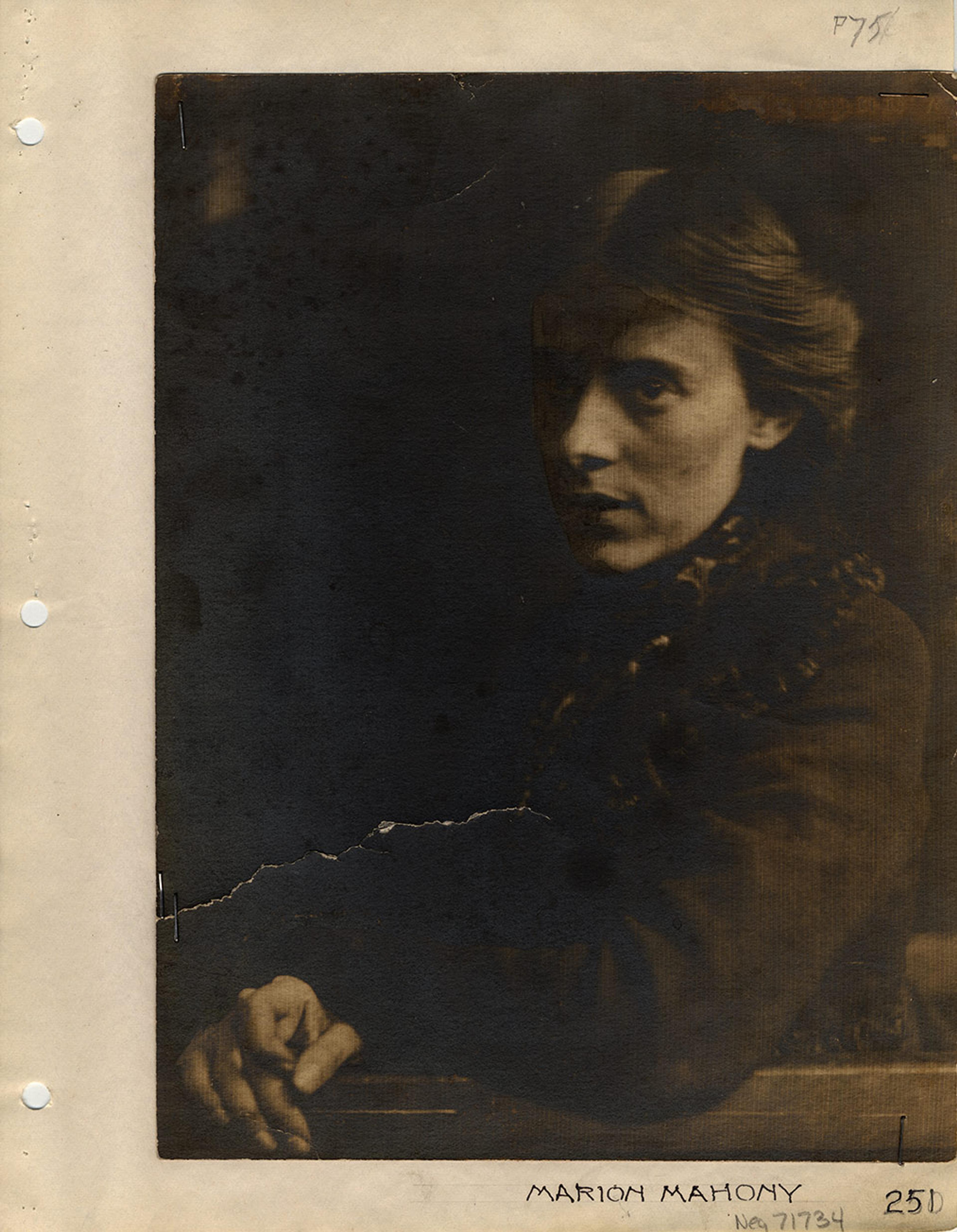 Sepia-toned vintage photo of a woman with a serious expression, partially in shadow.