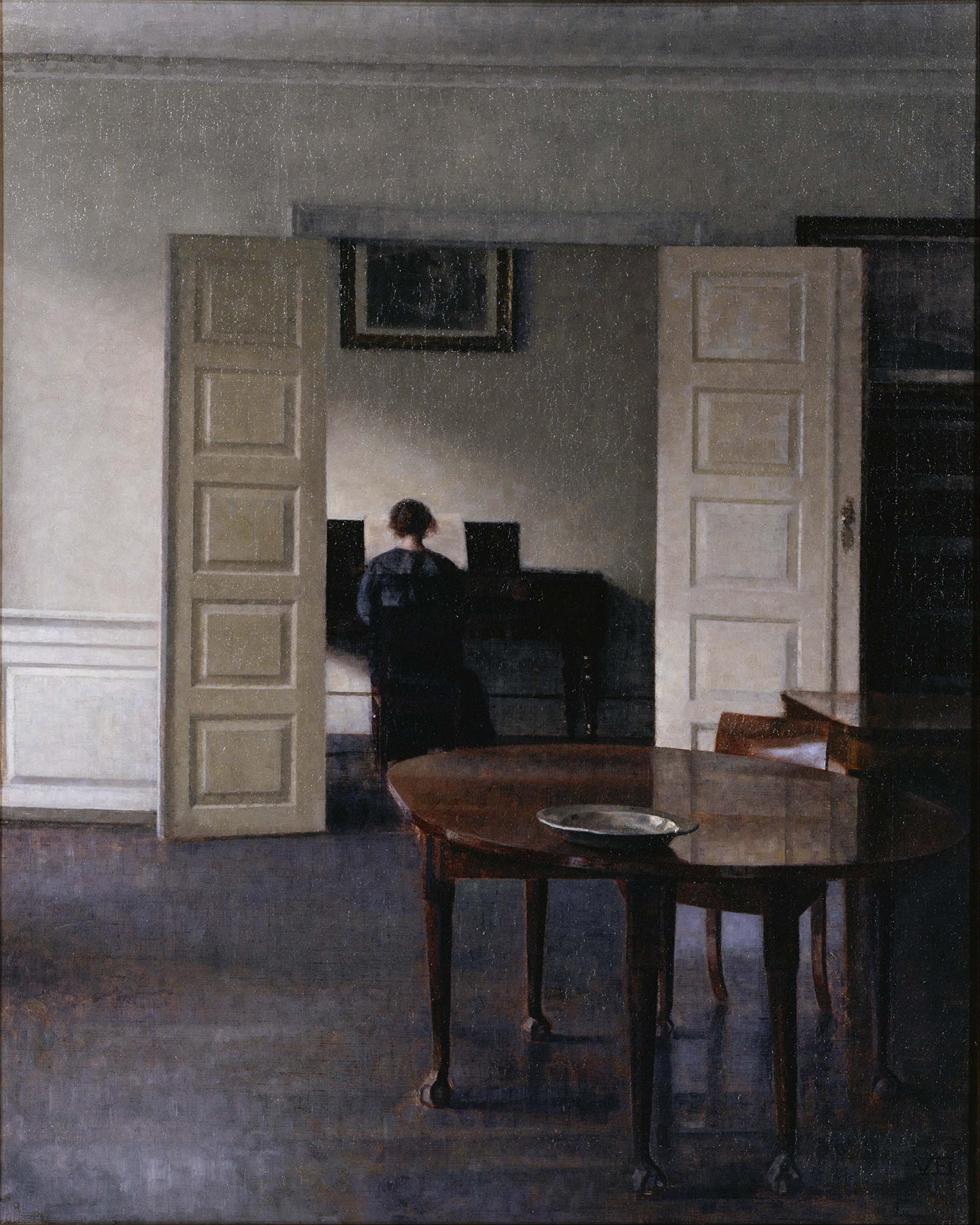 Painting of a woman playing piano in a dim room, viewed through an open door, with a wooden table in the foreground.