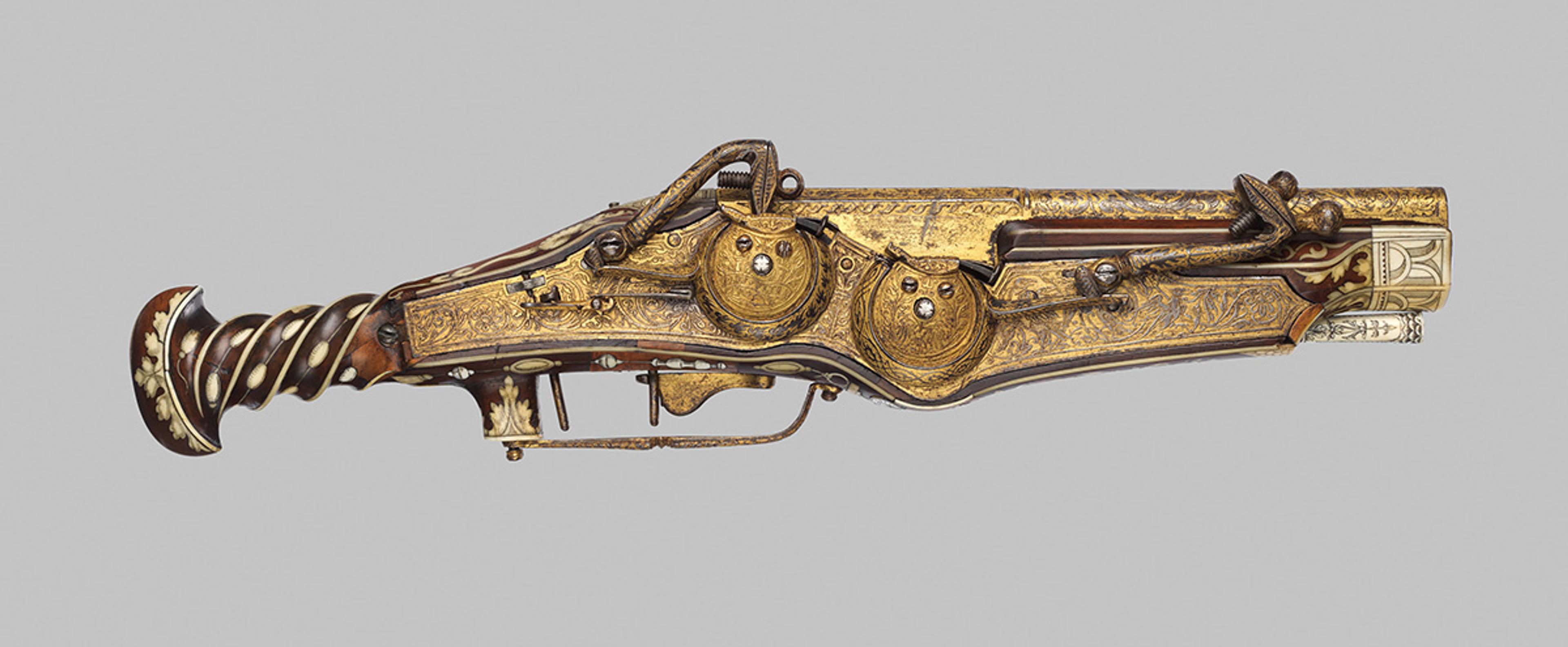Intricately decorated antique flintlock pistol with gold embellishments ornate handle and detailed engravings on display.